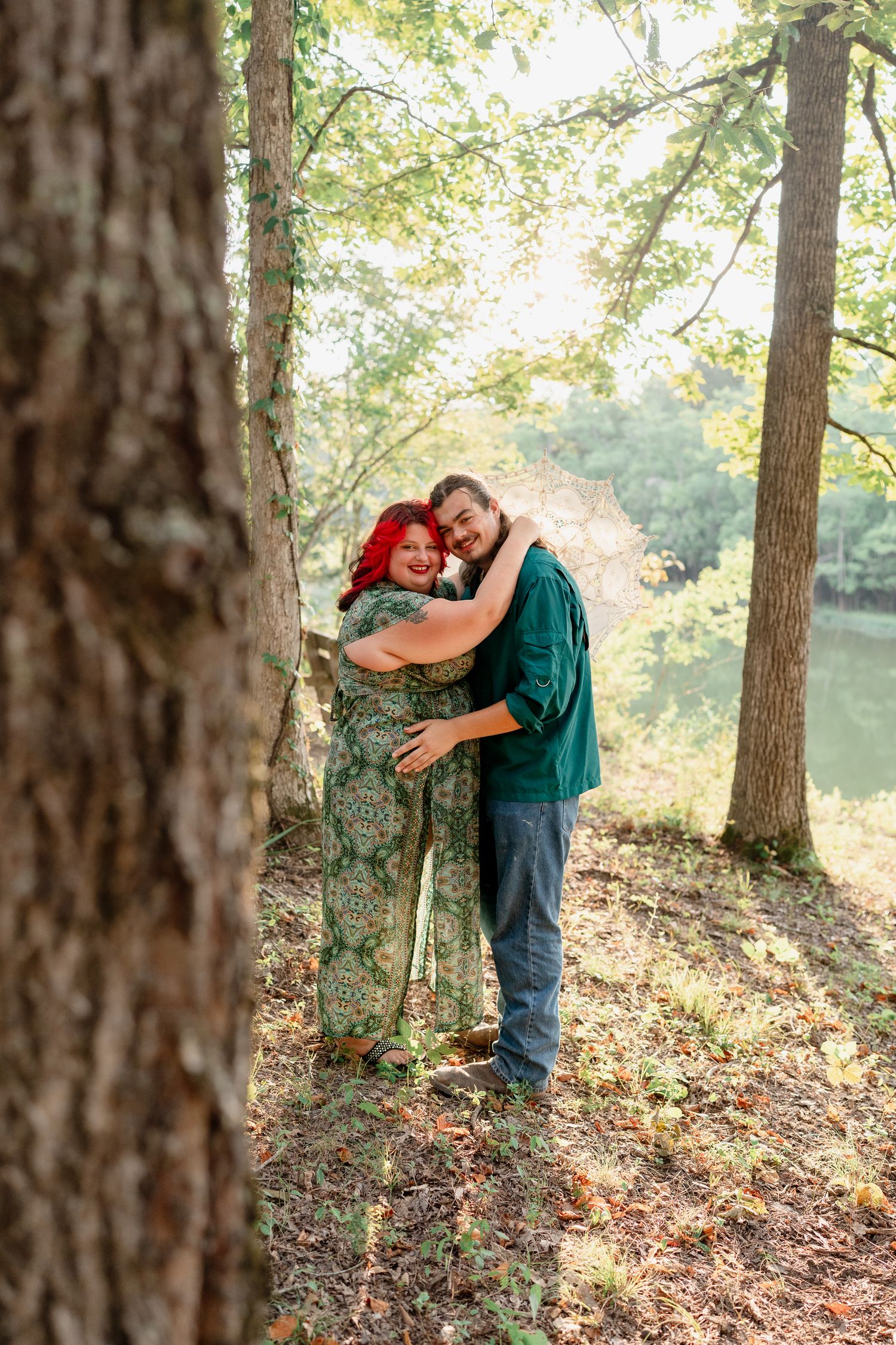 Romantic couple embracing on a wooded hillside near a lake on an autumn afternoon.