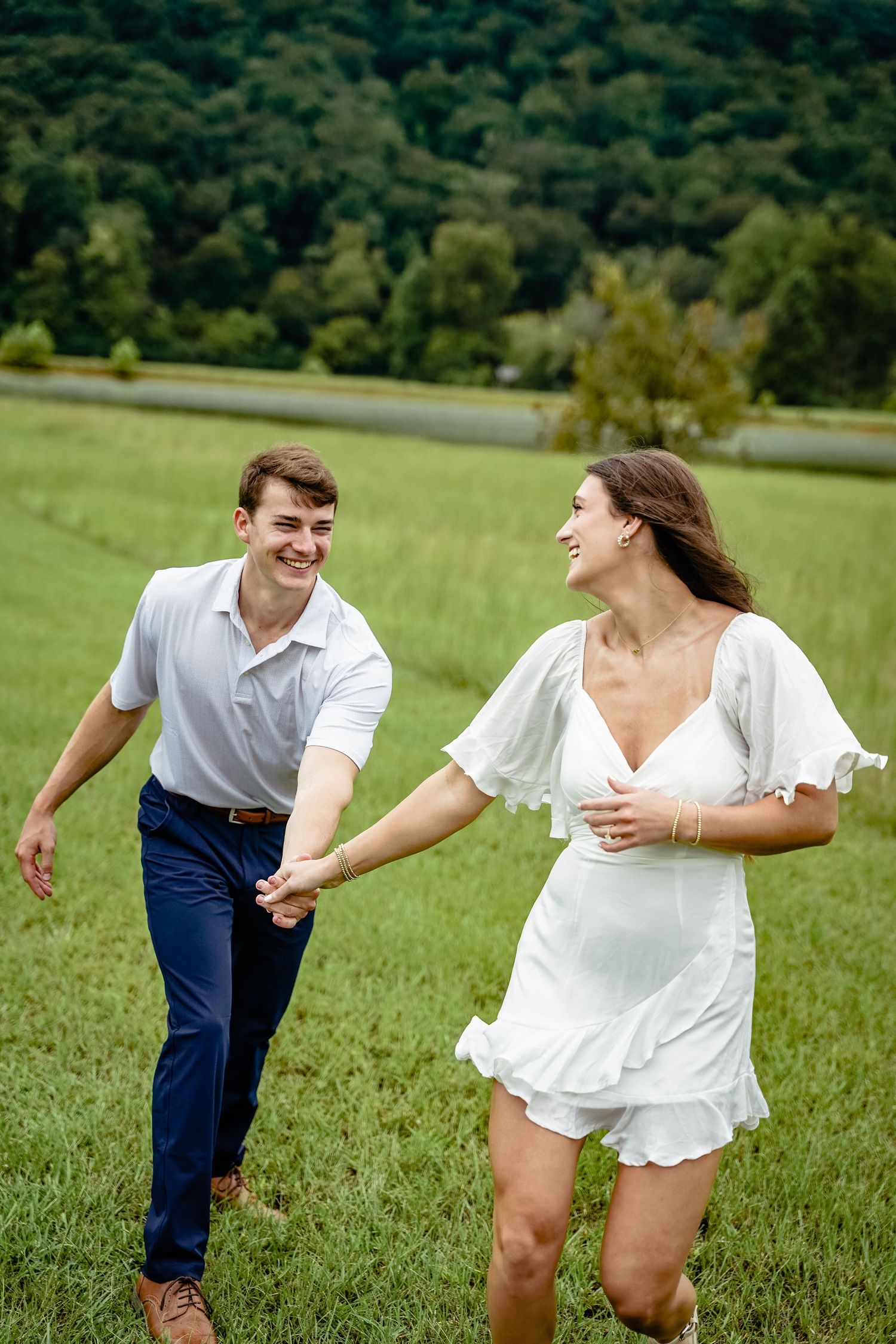 A playful moment captured in a lush green meadow with hills in the background.