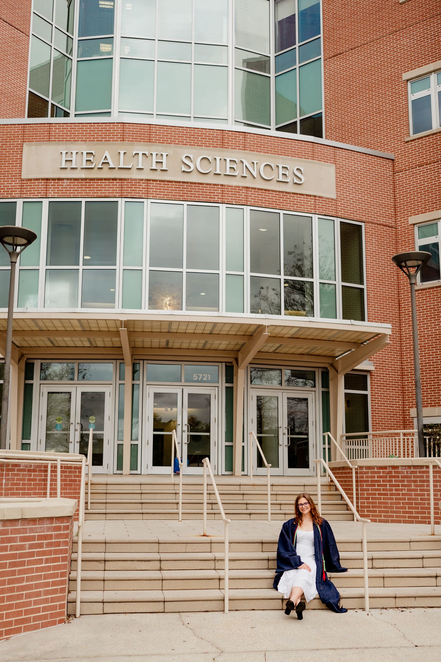 Modern brick Health Sciences building exterior with glass windows and concrete steps.