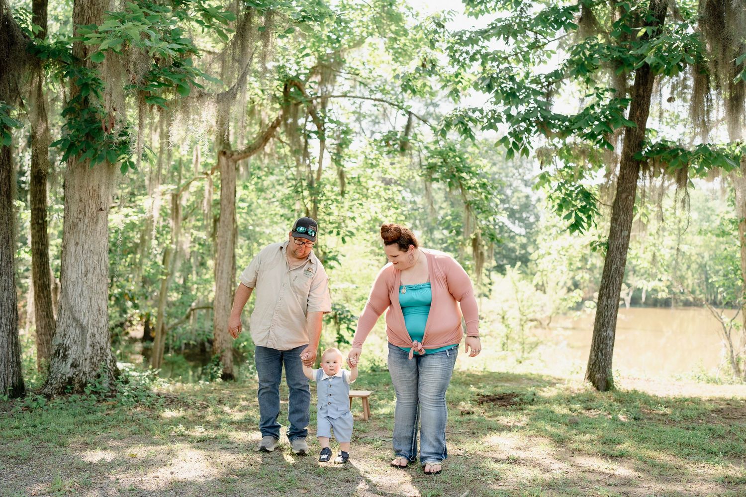 Family walking together hand in hand through a scenic wooded path.