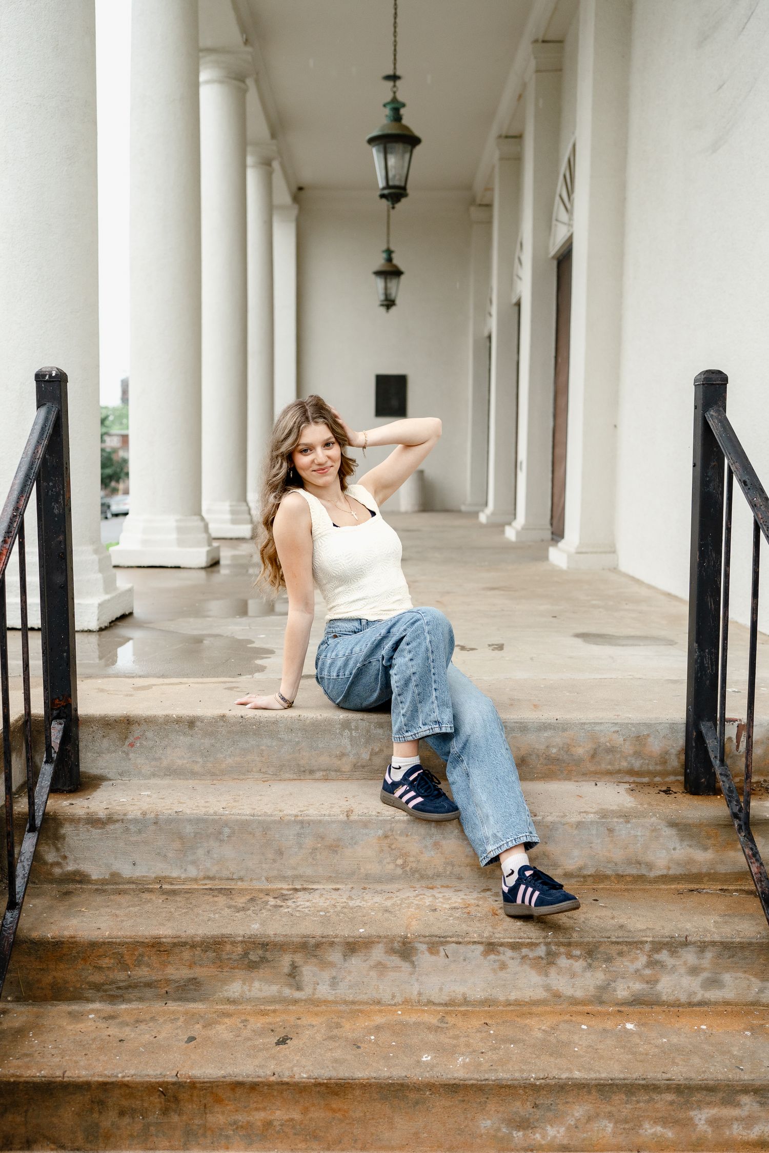 Artistic portraits taken in a white columned corridor with vintage architecture.