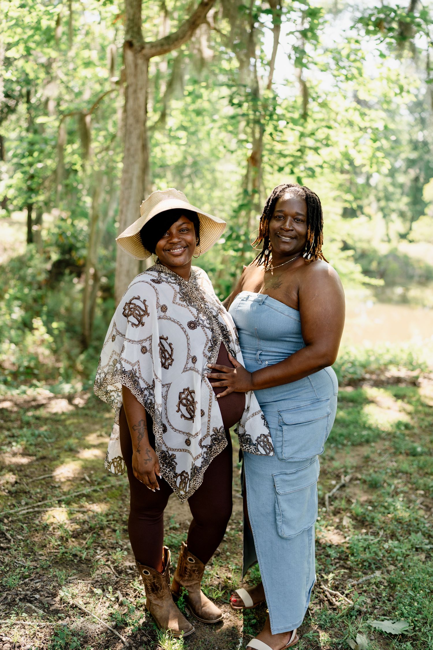 Two people pose together in a forest clearing, wearing contrasting casual and dressy outfits.