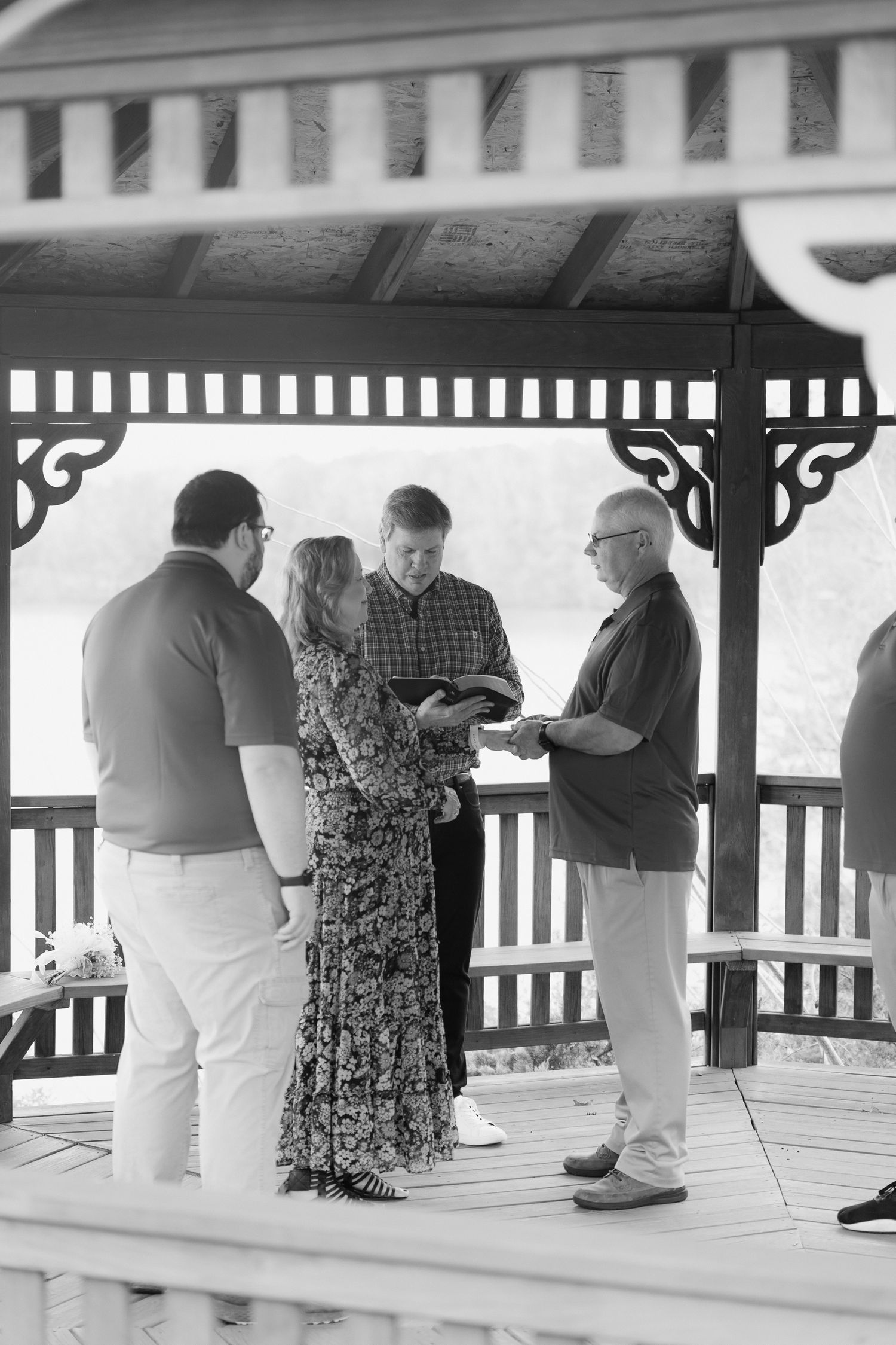 Couple exchanges vows in a gazebo wedding ceremony with an officiant outdoors.