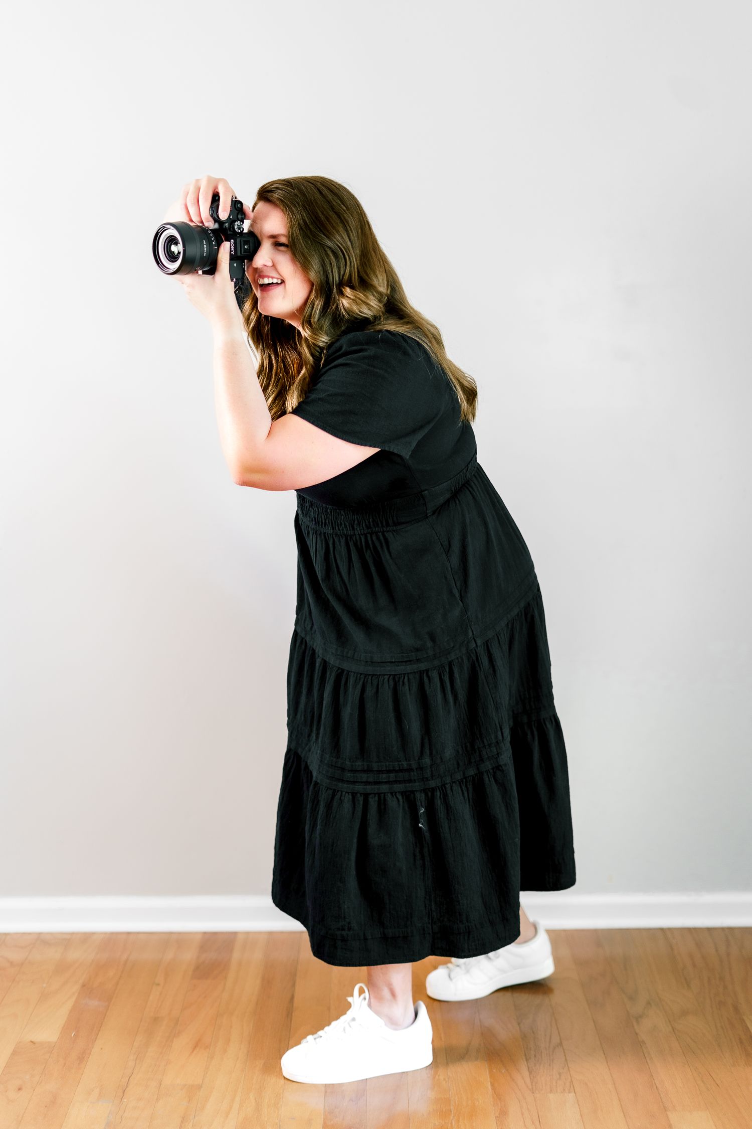 A series of low-angle photography shots with someone wearing a black dress and sneakers.