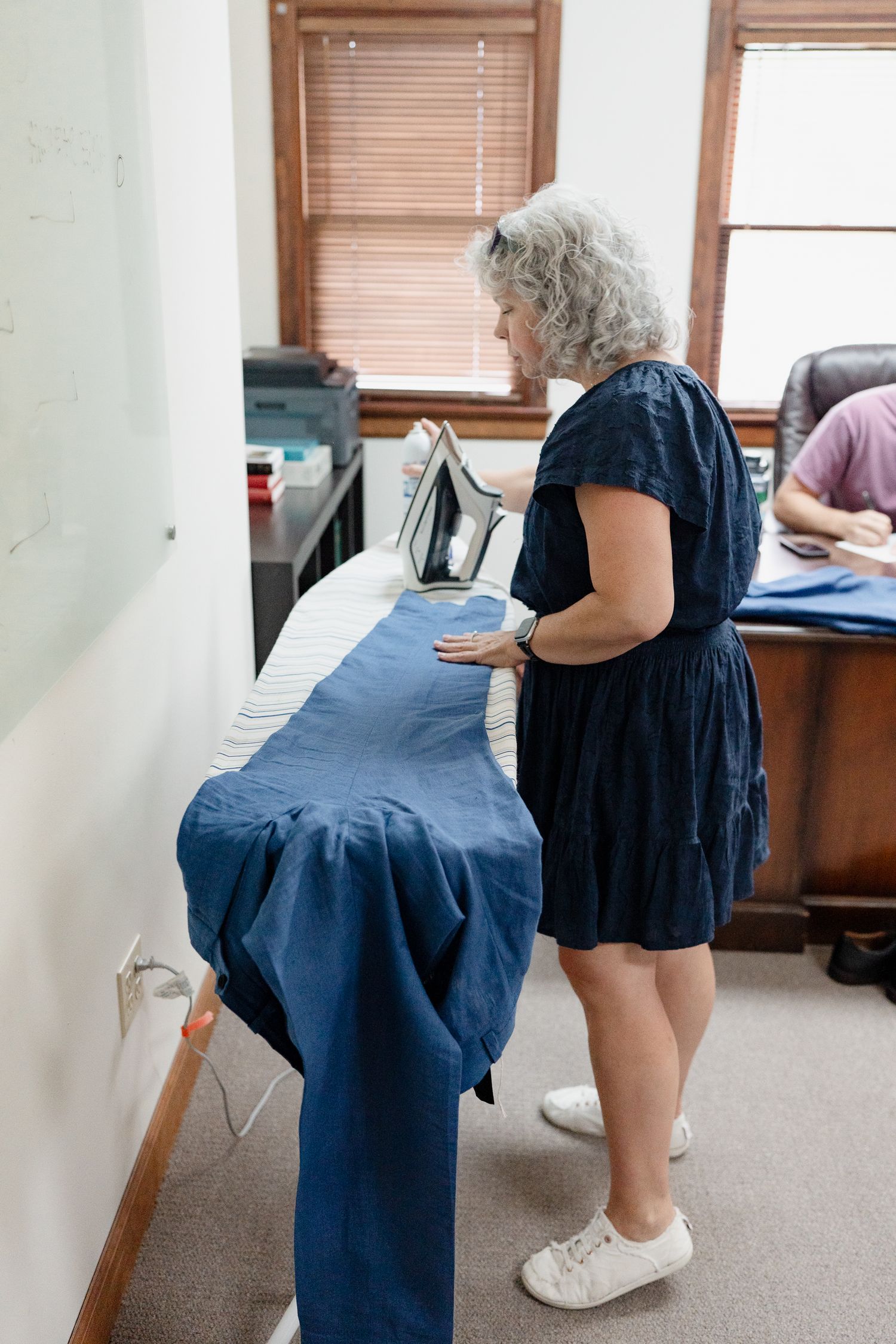 A series of photos showing someone in blue scrubs demonstrating proper stretching techniques in an office setting.