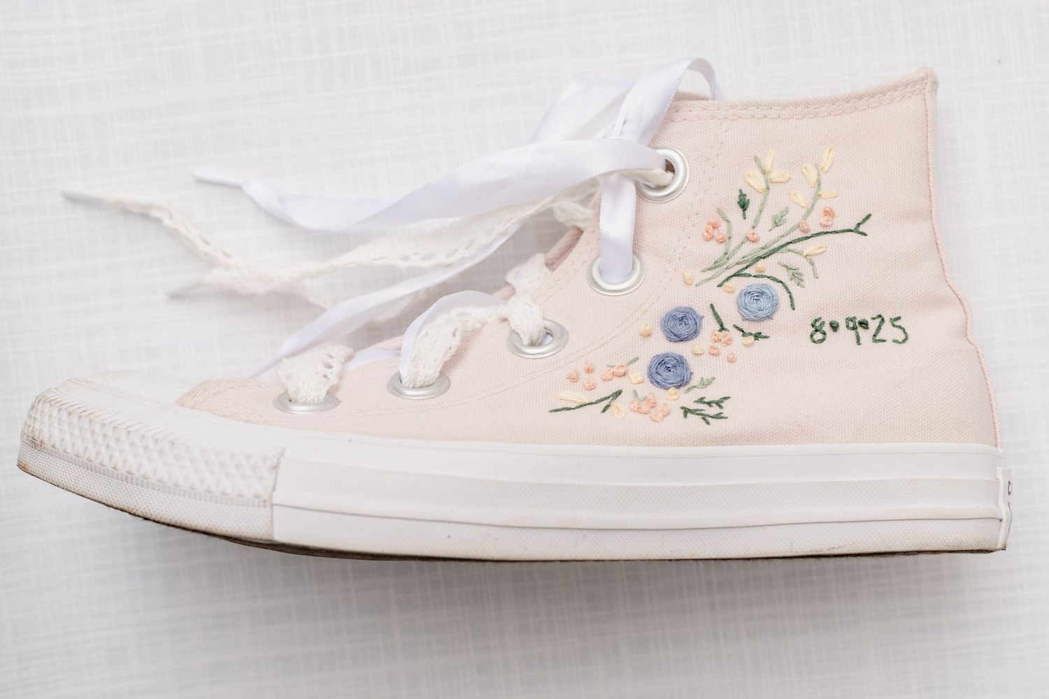 Delicate floral embroidered white canvas sneakers displayed in multiple angles on a light background.
