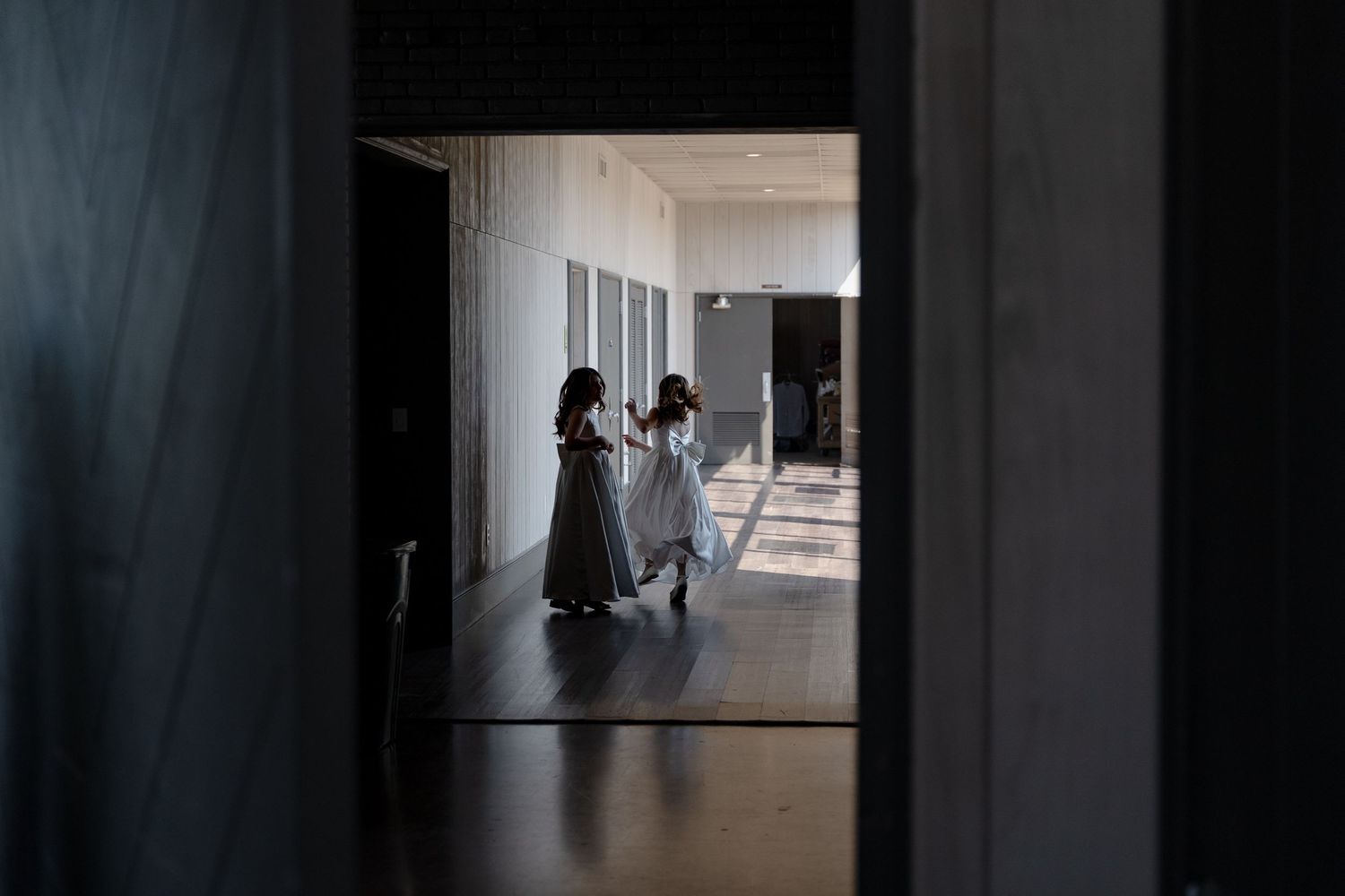 Dark hallway with natural light streaming through doorways creating dramatic shadows.