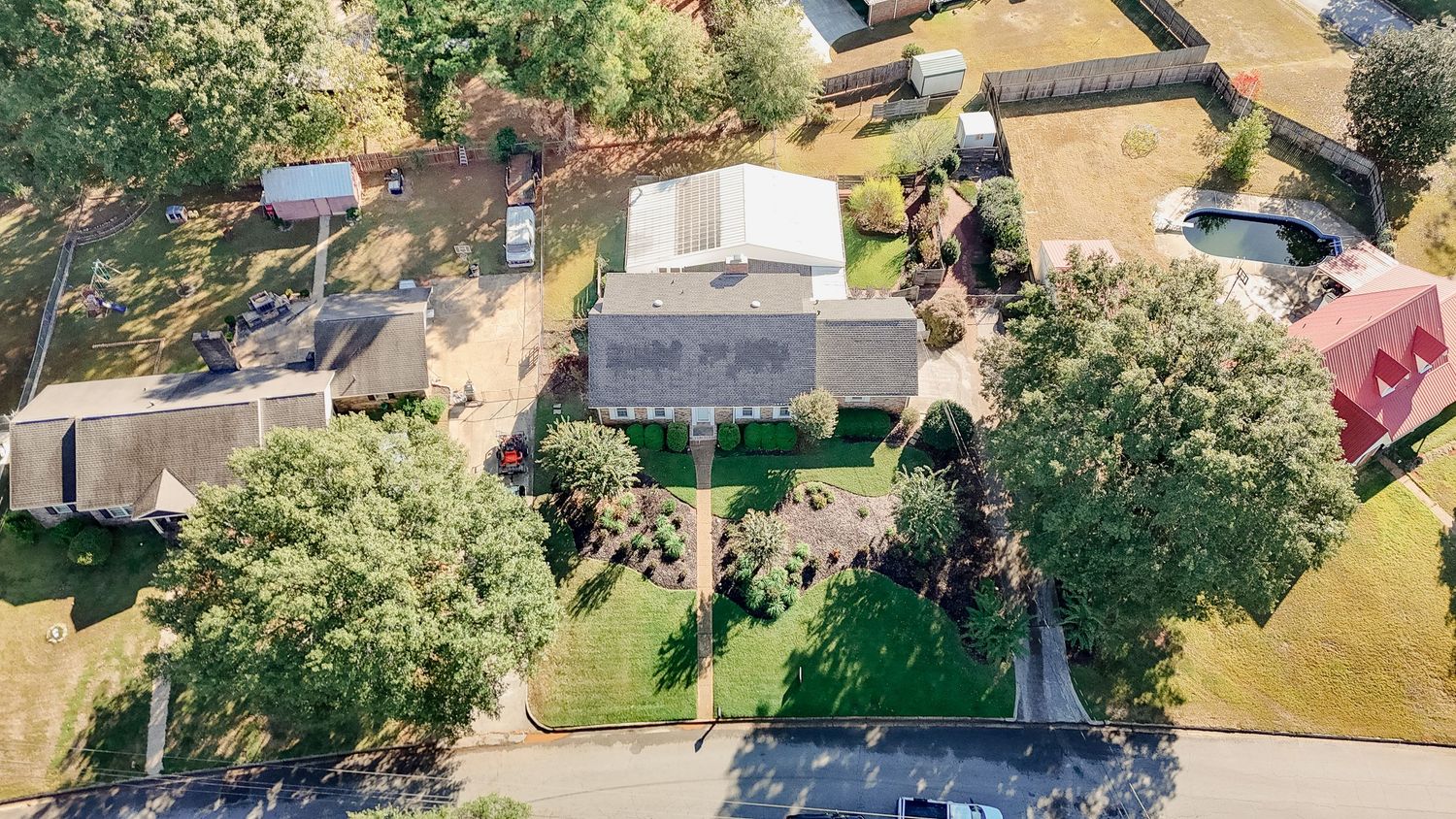 Aerial view of a residential neighborhood with houses, green lawns, and trees during summer.