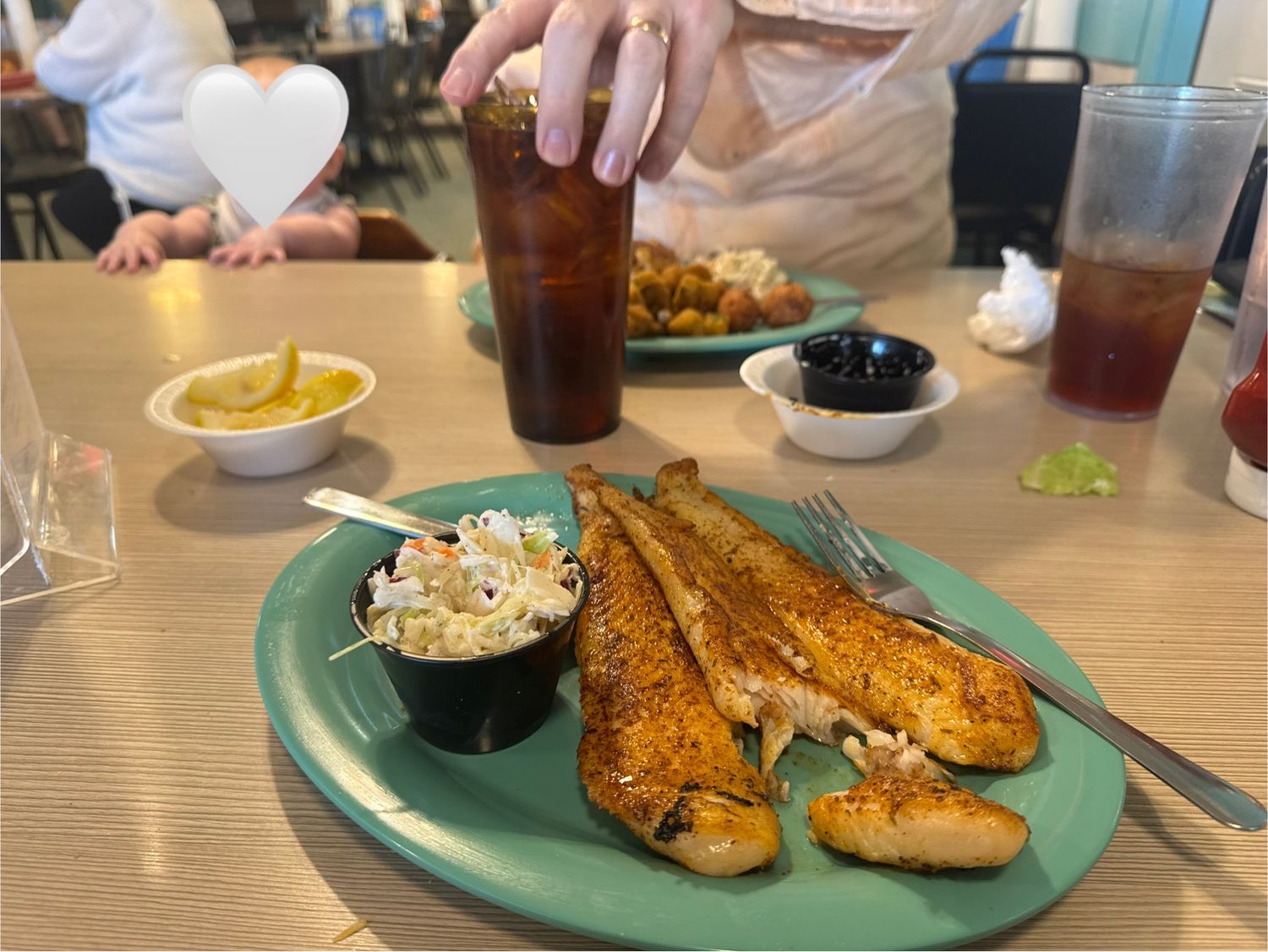 Plates of grilled fish and sides served at a casual restaurant.