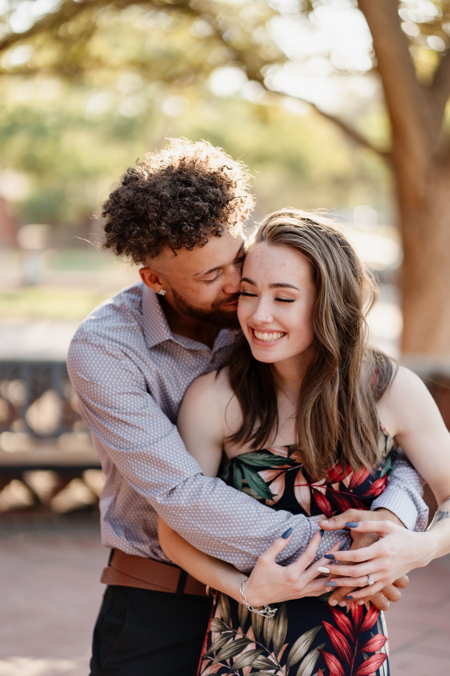 A couple shares intimate moments during their outdoor portrait session in natural lighting.