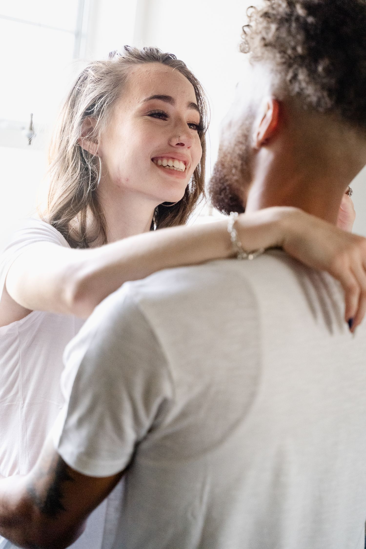 Intimate portrait of couple sharing joyful moment in bright indoor setting.