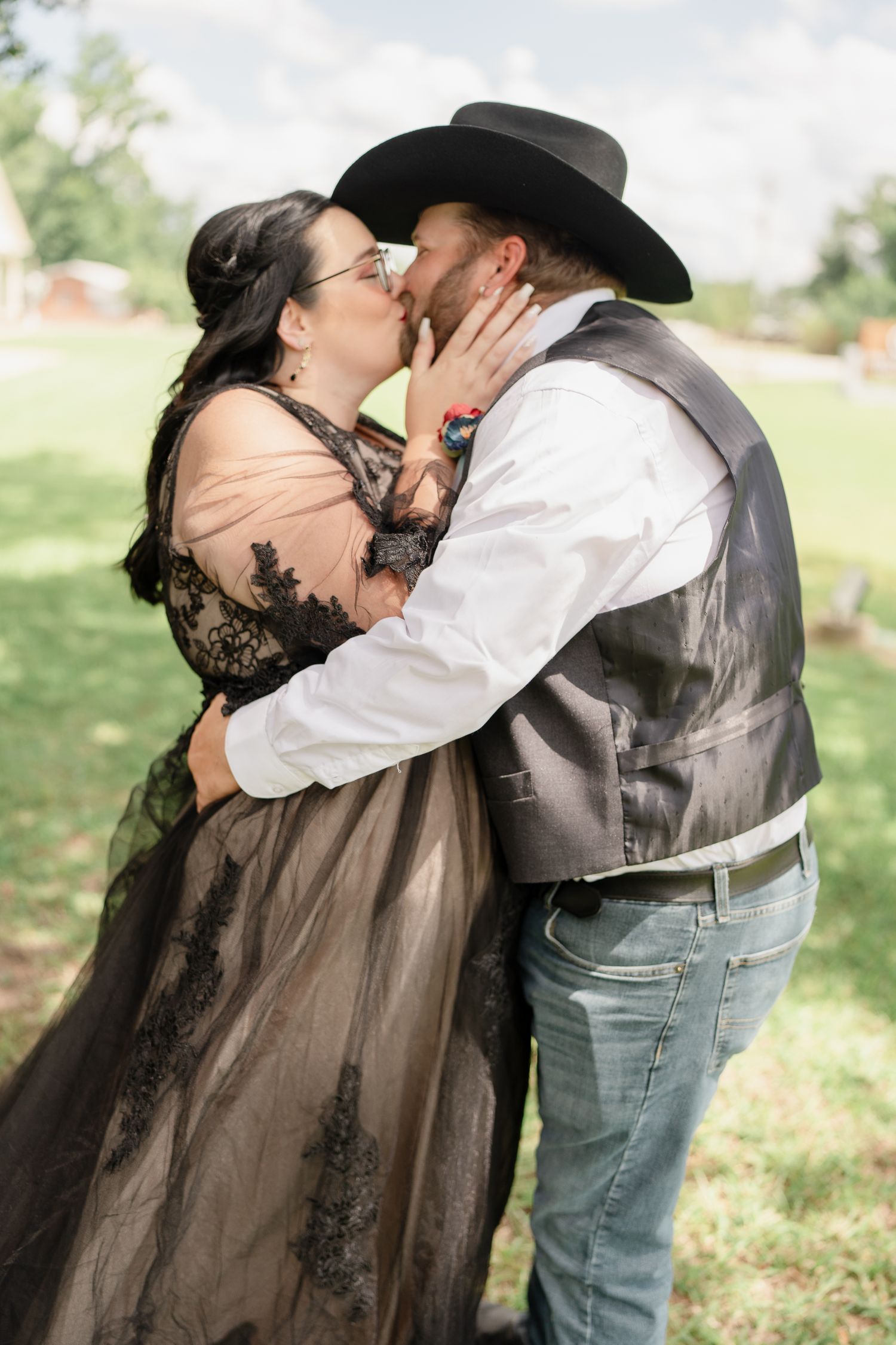 Romantic moment between couple in western wedding attire outdoors.