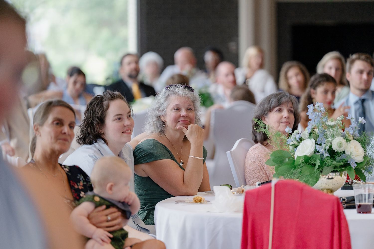 Wedding reception guests enjoying the celebration at decorated dining tables.