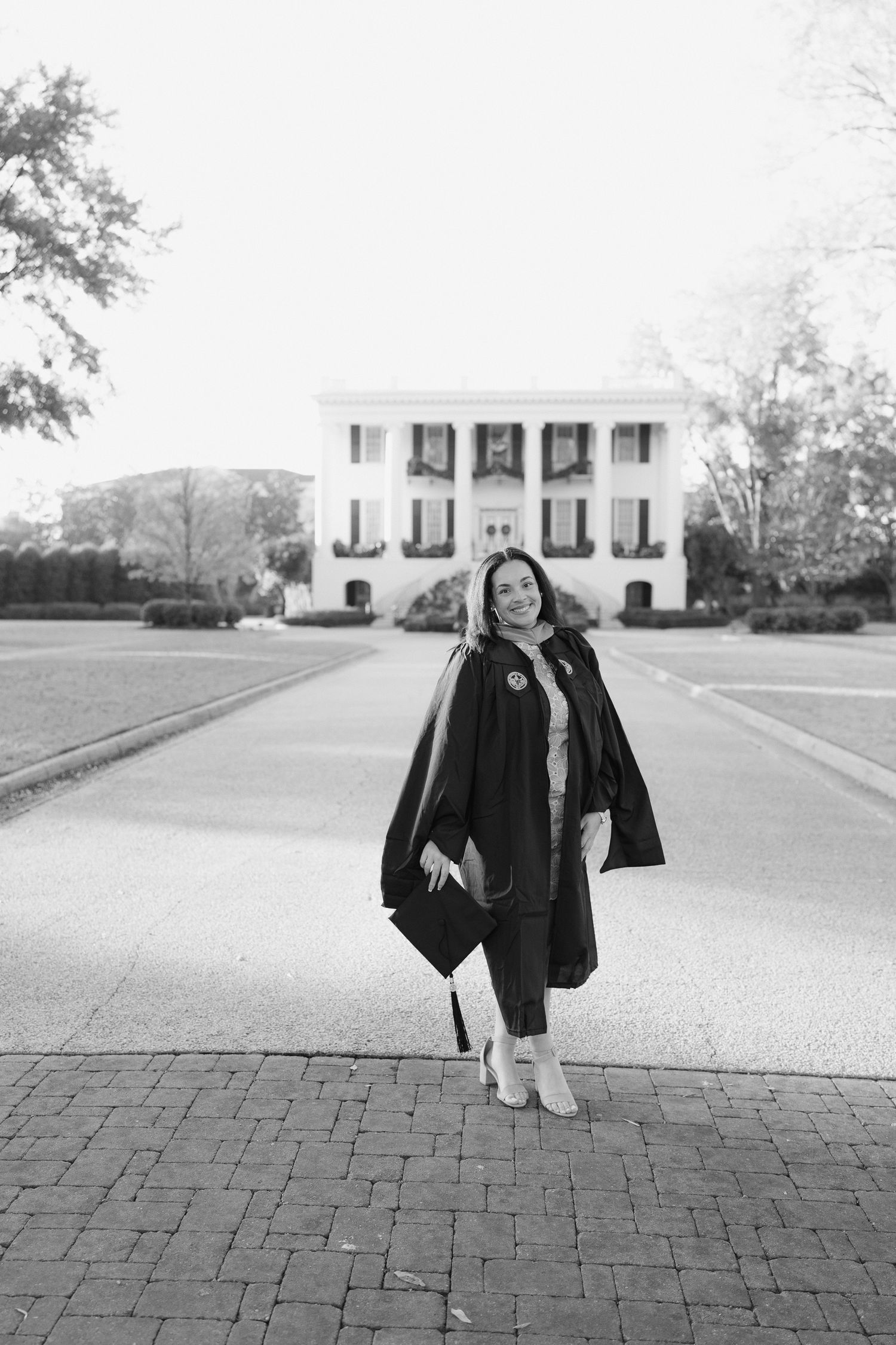 Black and white graduation portraits captured in front of a classic white columned building.