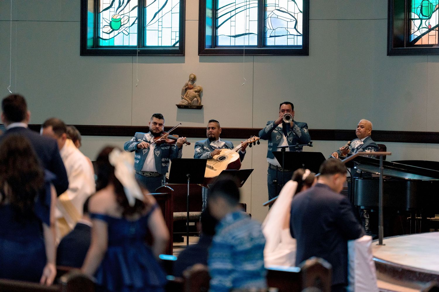 Musicians rehearse together in a studio space with instruments and sheet music stands.