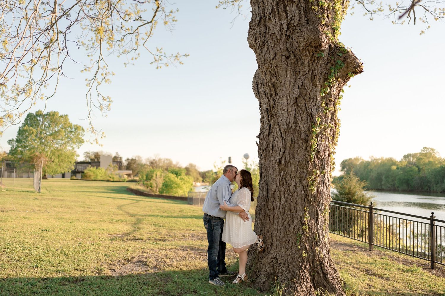 Romantic couple portraits captured under a tree during golden hour.