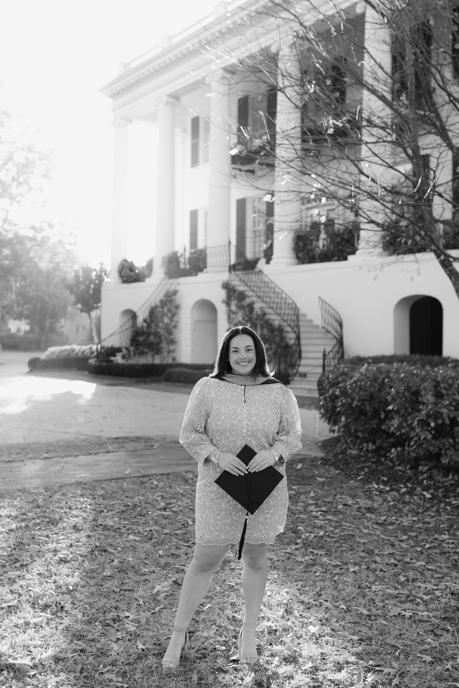 Black and white graduation photos in front of a white columned building with autumn leaves.