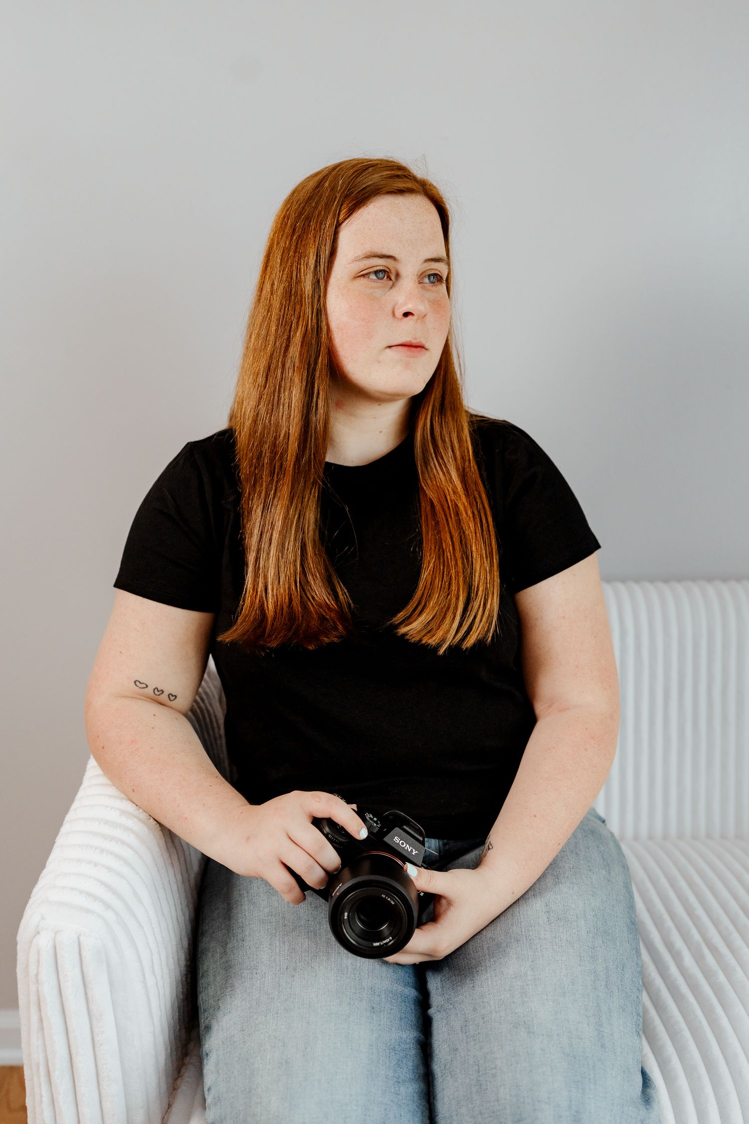 Person lounging on white modern sofa while holding camera in casual indoor setting.