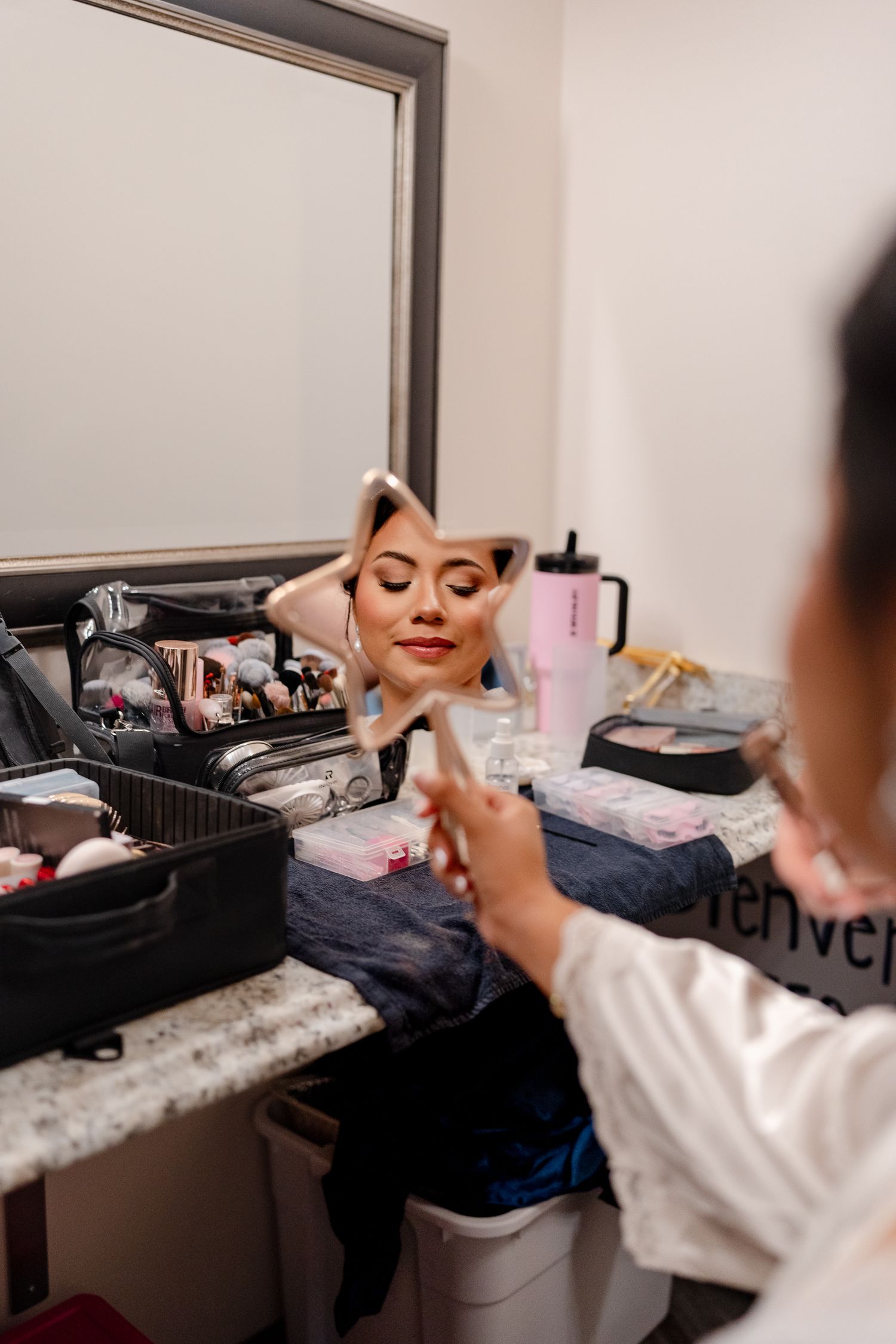 A sequence of photos showing someone getting ready in front of a mirror with makeup and beauty products.