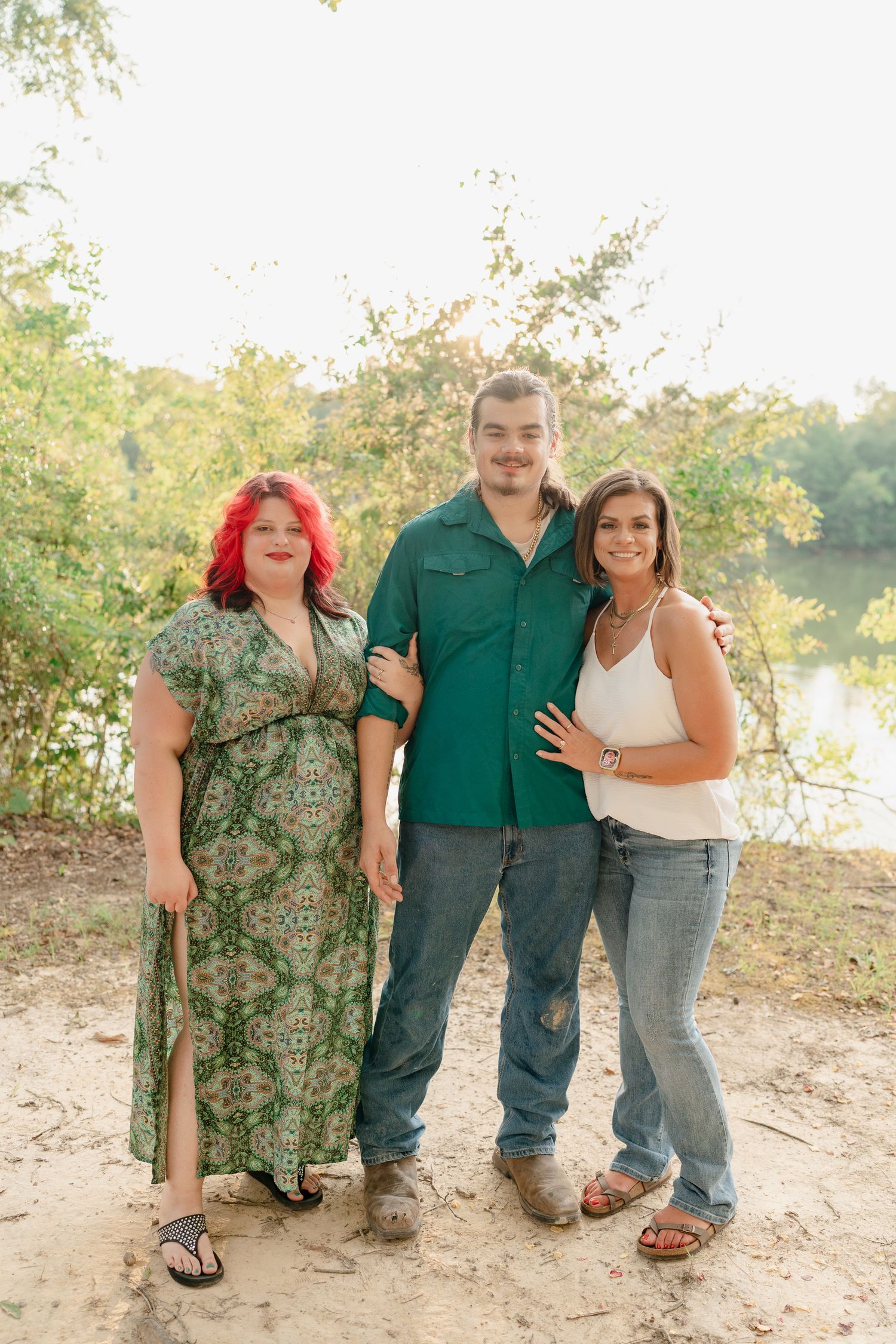 A casual group photo session by a lake with people in relaxed clothing.