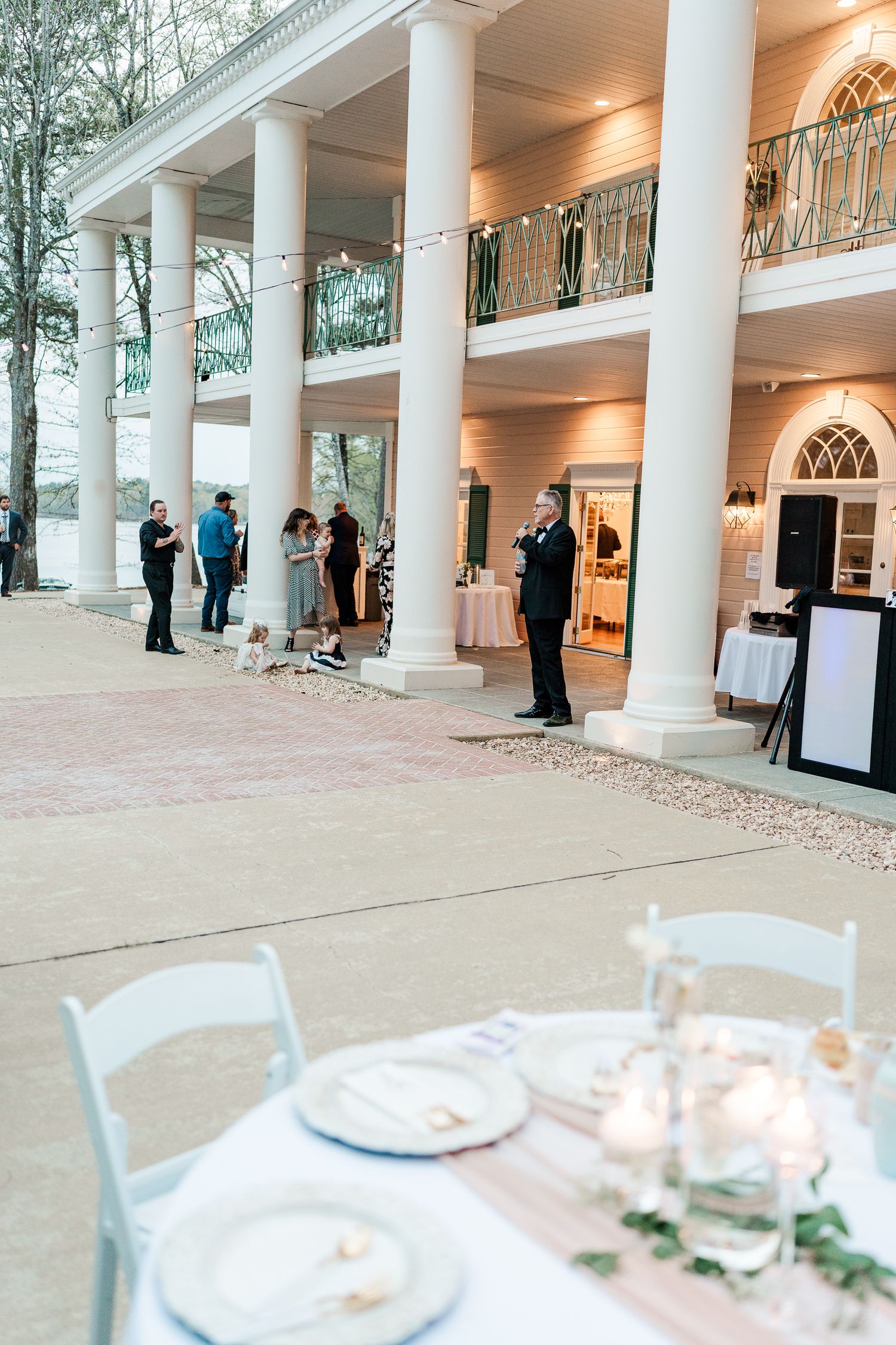 Elegant outdoor venue with white columns and place settings for a formal event.