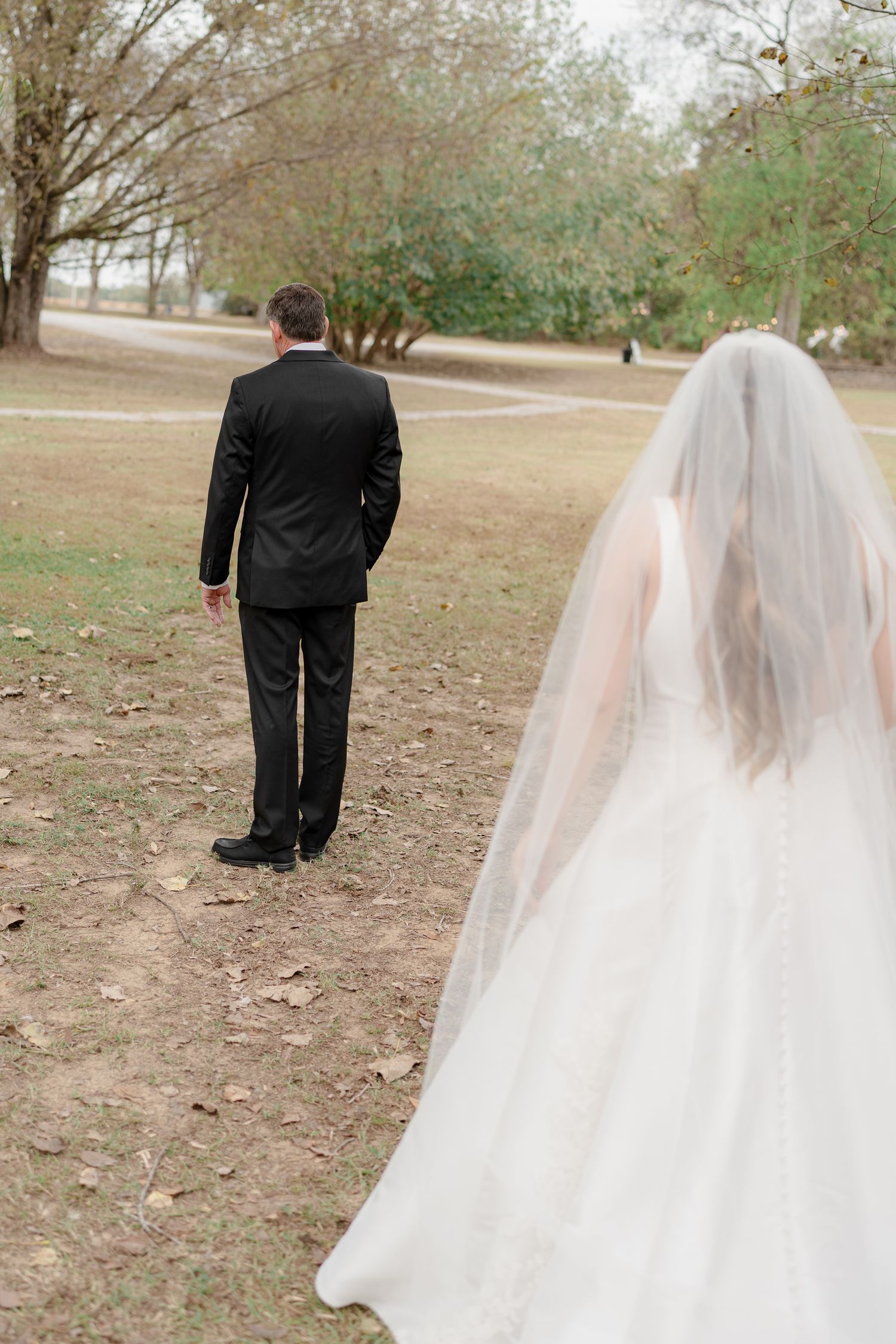 A romantic first look sequence between a bride and groom walking outdoors on a fall day.