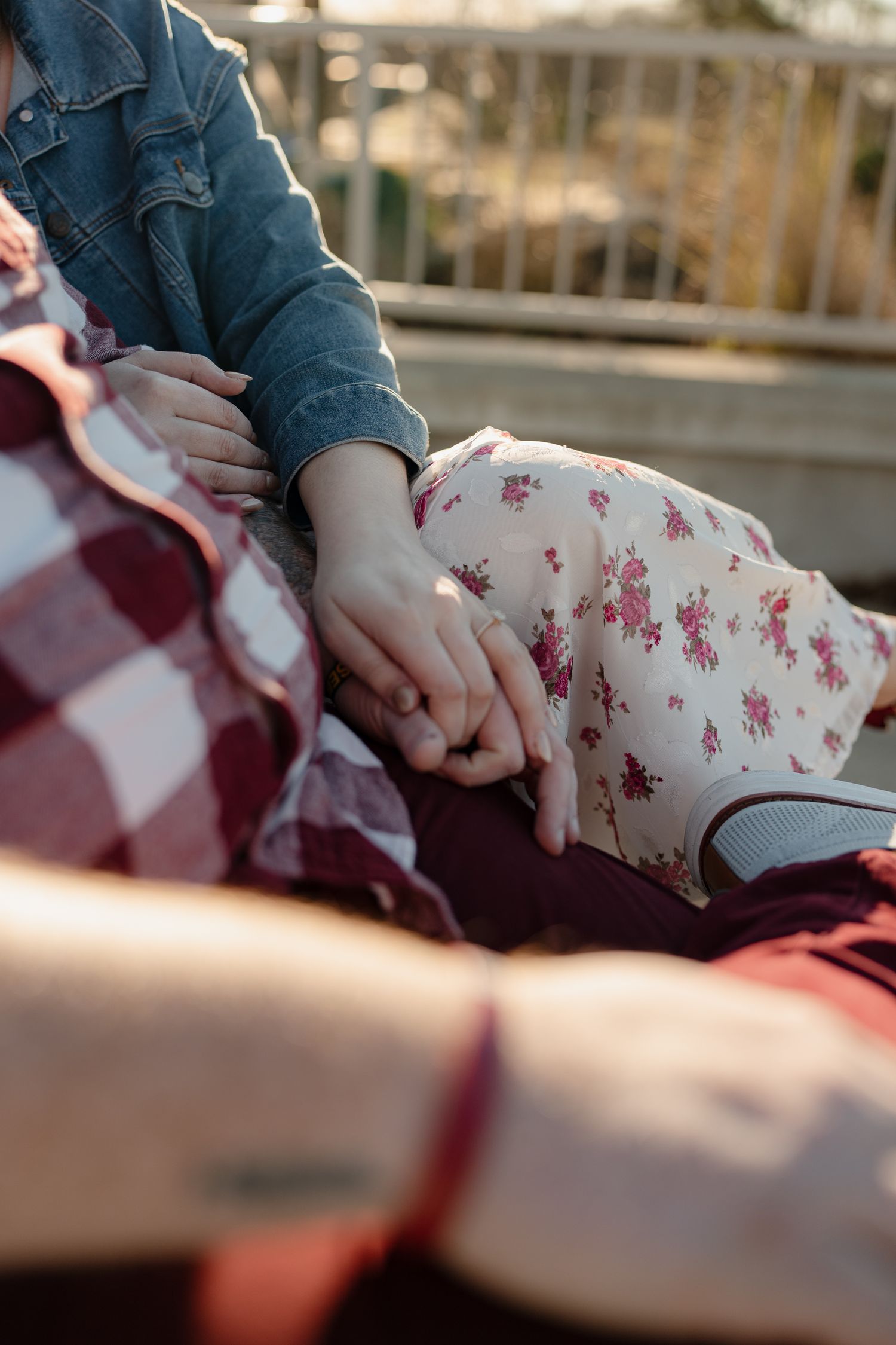 A couple in casual attire sharing an intimate moment outdoors during golden hour.