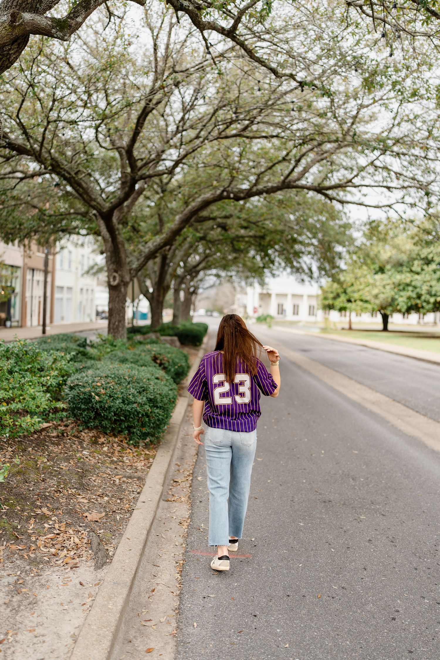 Walking shots on tree-lined path showing purple sports jersey and casual style.