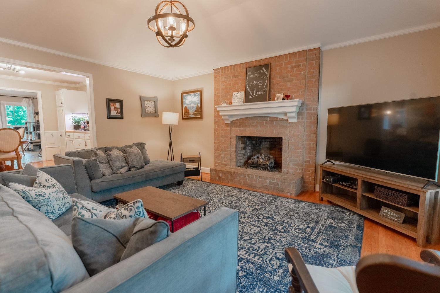 Modern living room features exposed brick walls, plush gray sectional sofa, and contemporary decor accents.