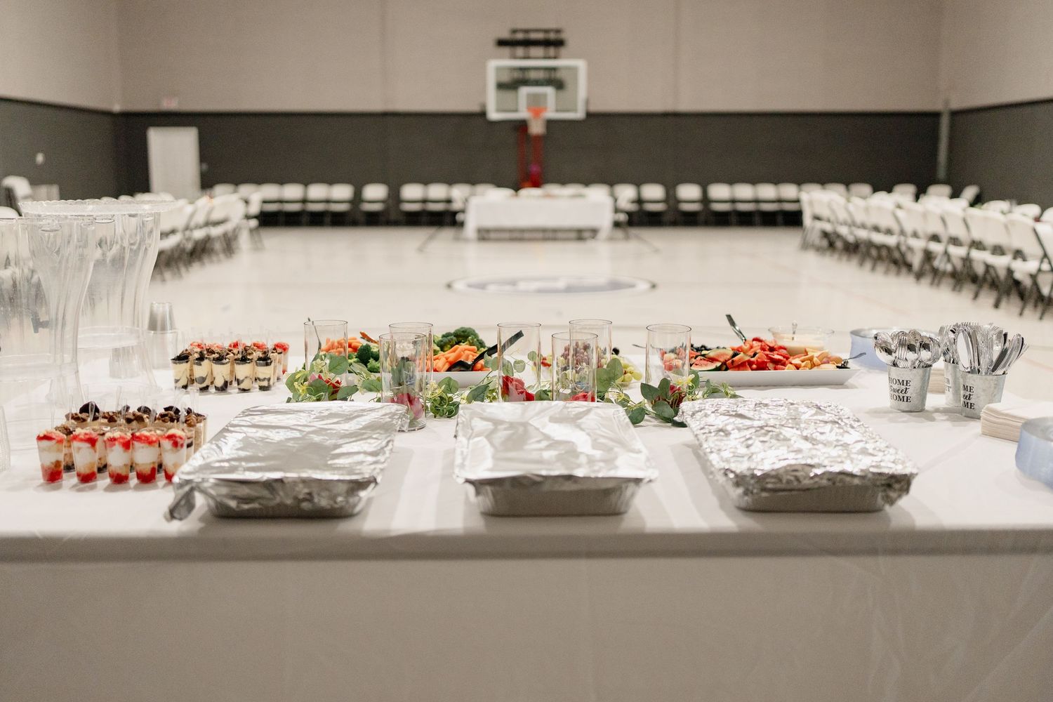 Wide view of catering setup with multiple serving stations and white tablecloths.