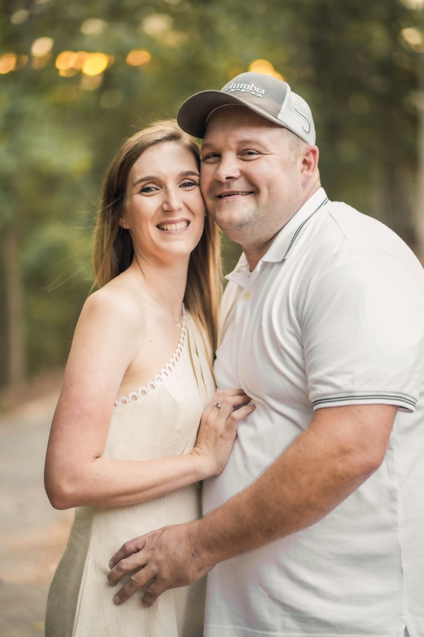 A romantic couple poses for engagement photos outdoors in natural lighting.