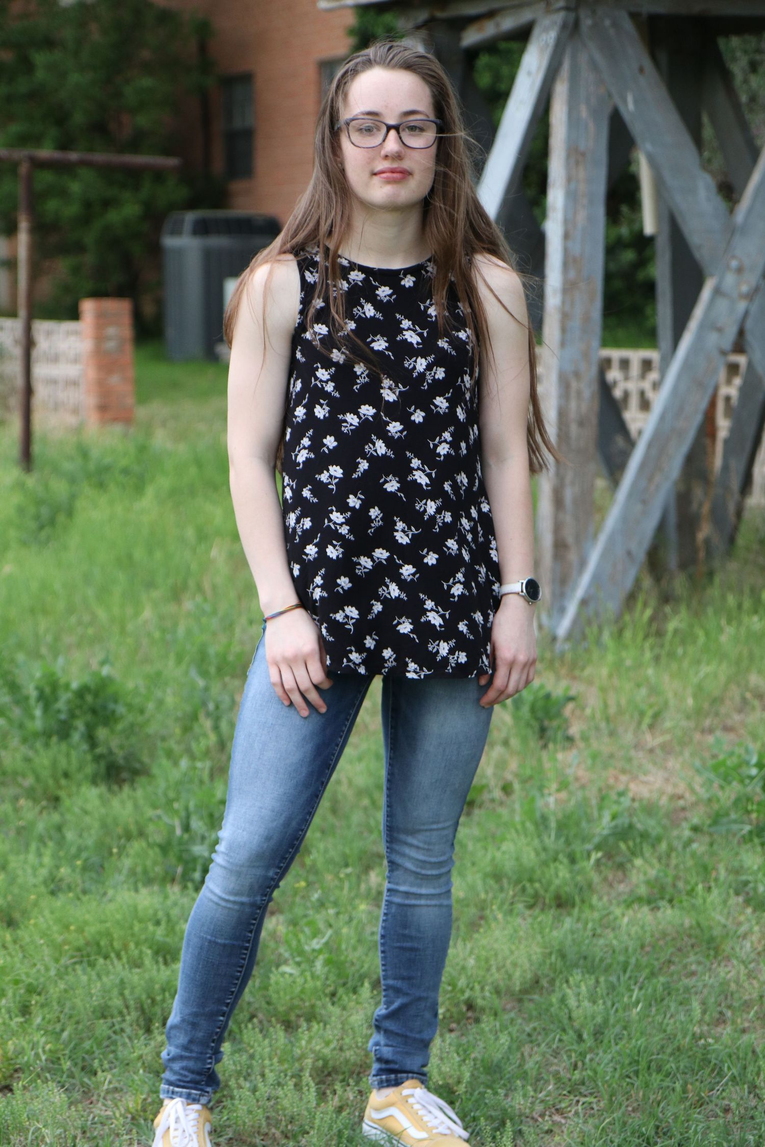 Casual outdoor portrait against rustic wooden bridge background.