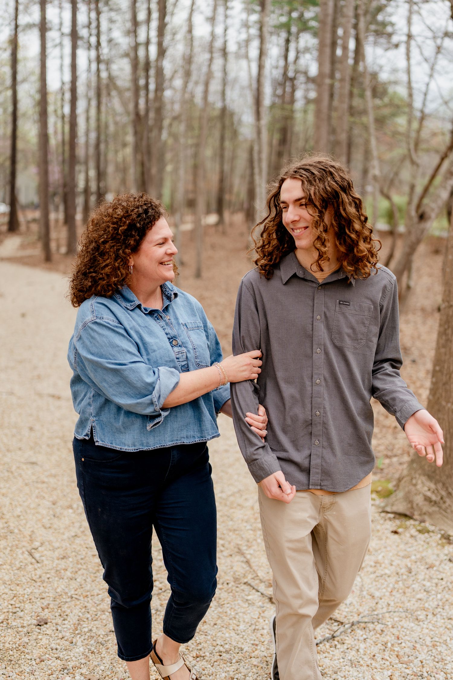 Playful moment captured between two people on a wooded path.