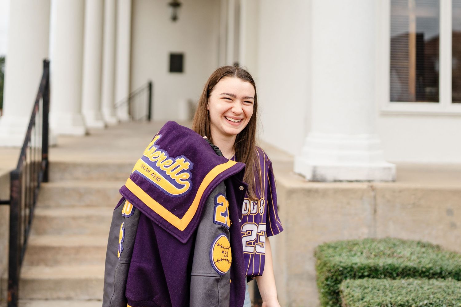 Athletic-inspired fashion shoot with purple and gold varsity jacket.