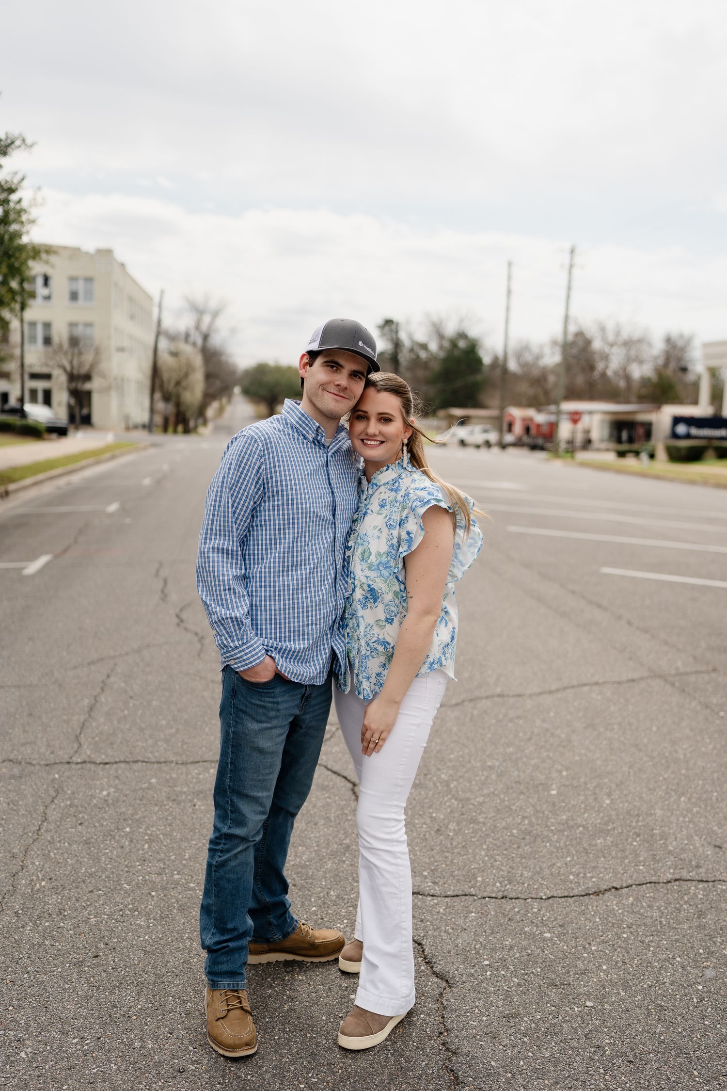 A couple shares a playful moment together on an empty street.