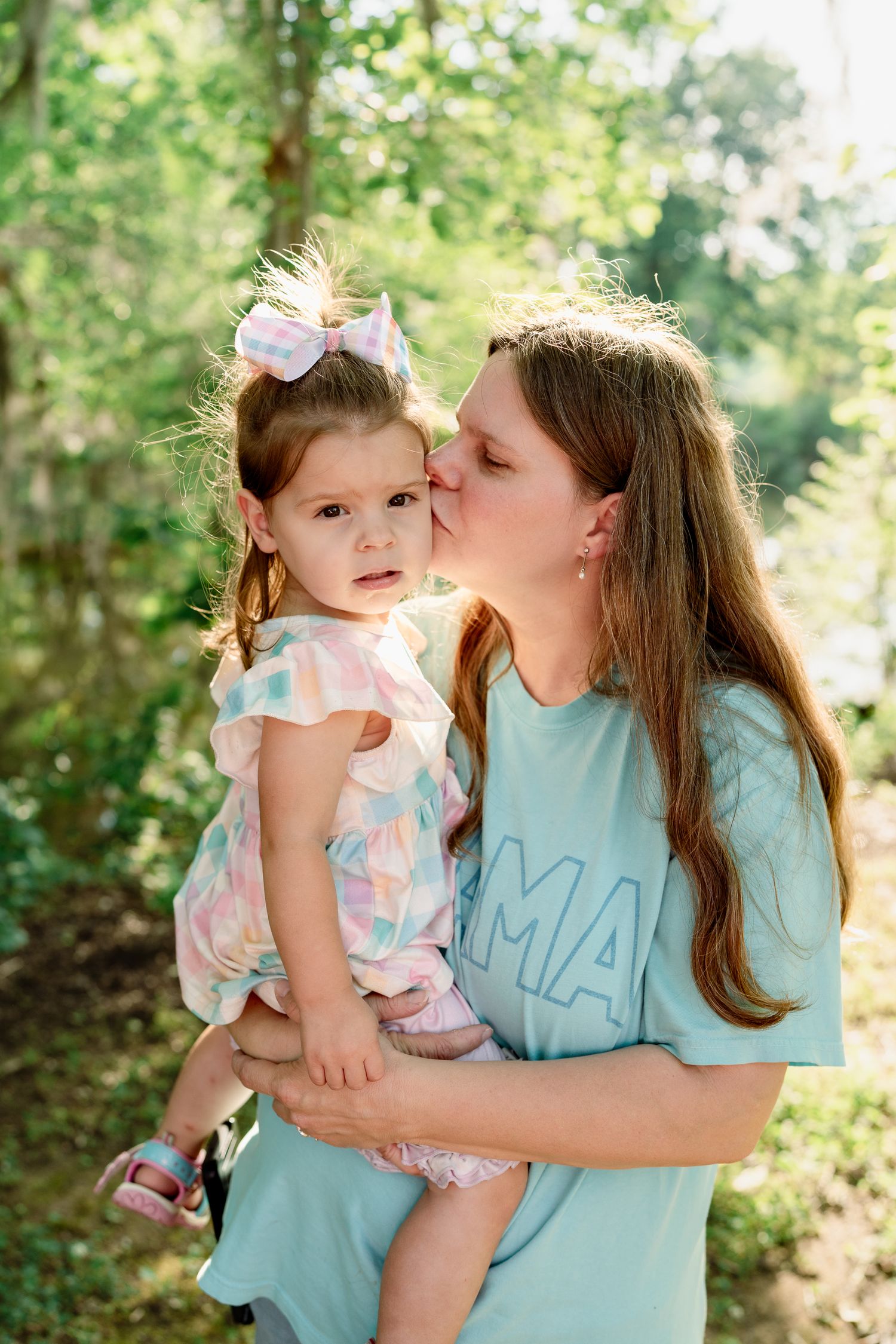 Sweet portraits showing affectionate moments between mother and child in matching light blue outfits outdoors.