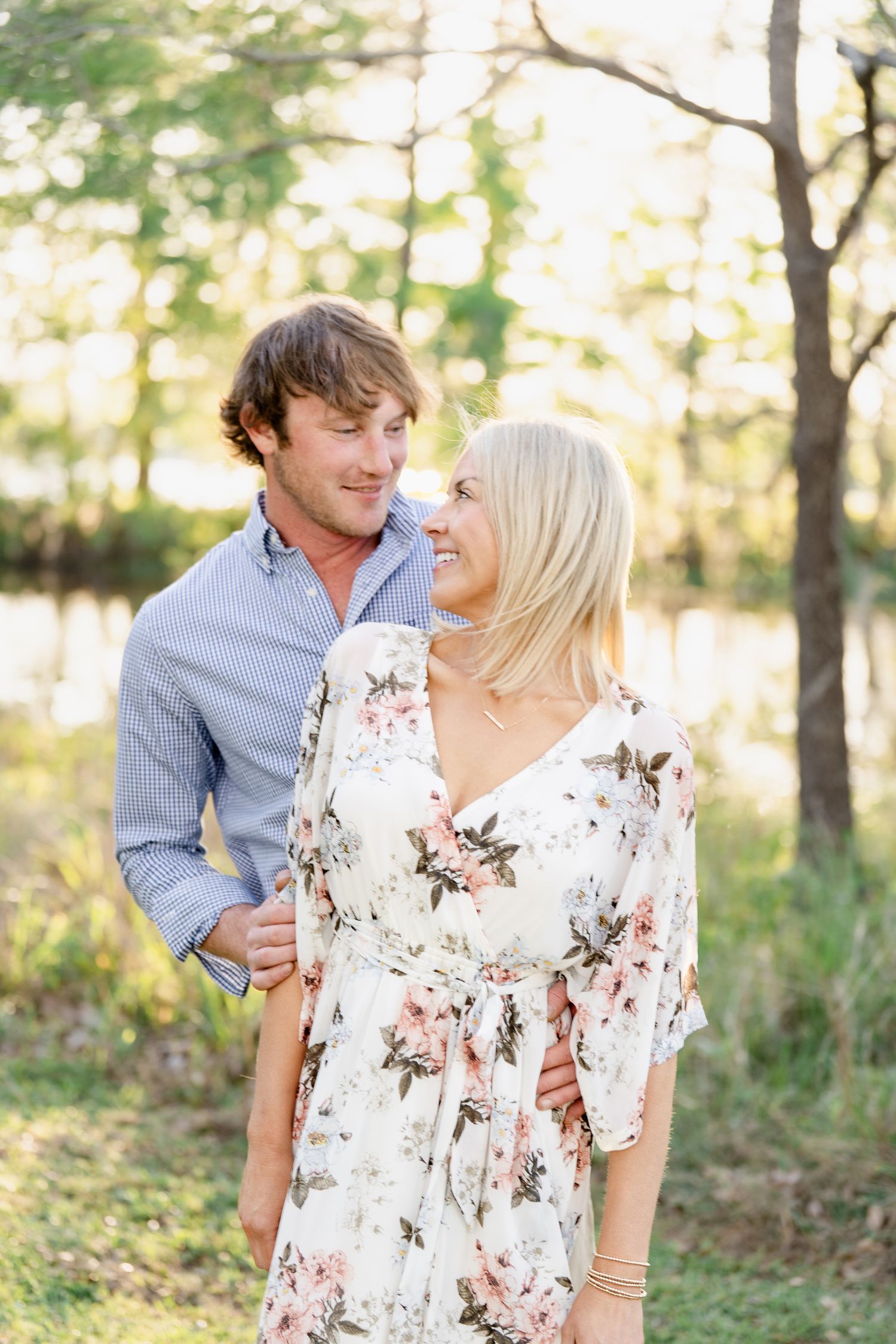 Tender moment captured between couple in coordinated outfits during sunset photo session.