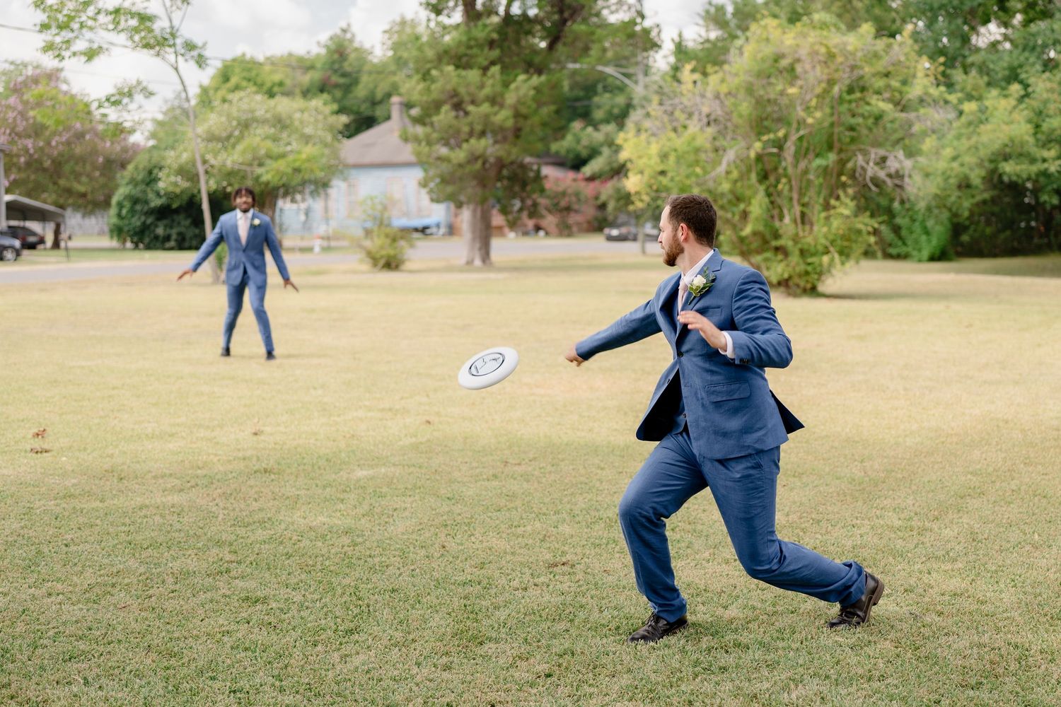 A person in blue denim performs a series of dynamic movements while playing frisbee in a grassy park.