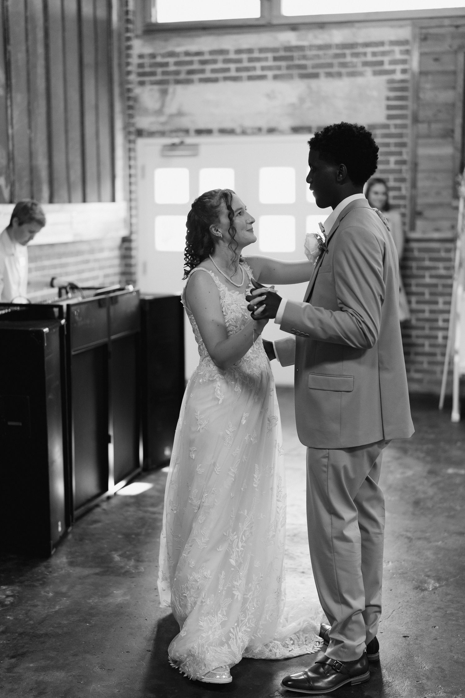 Black and white photo of newlyweds sharing their first dance at wedding reception.
