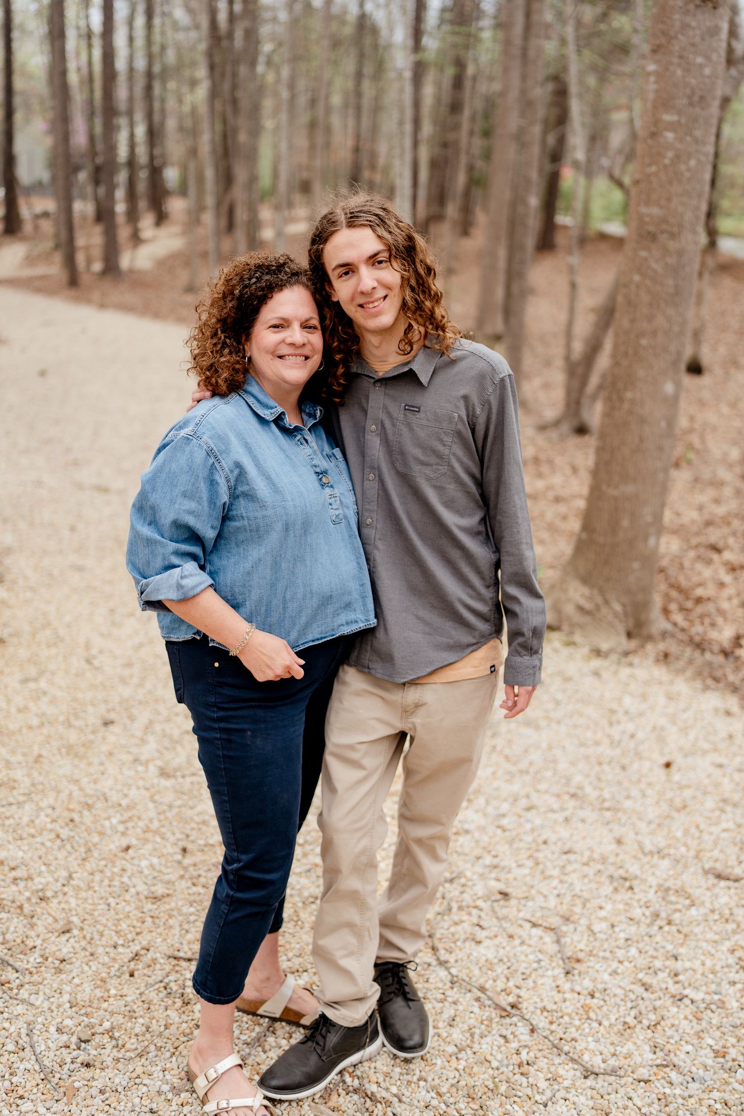 Candid shot of two people sharing a happy moment on a forest trail.