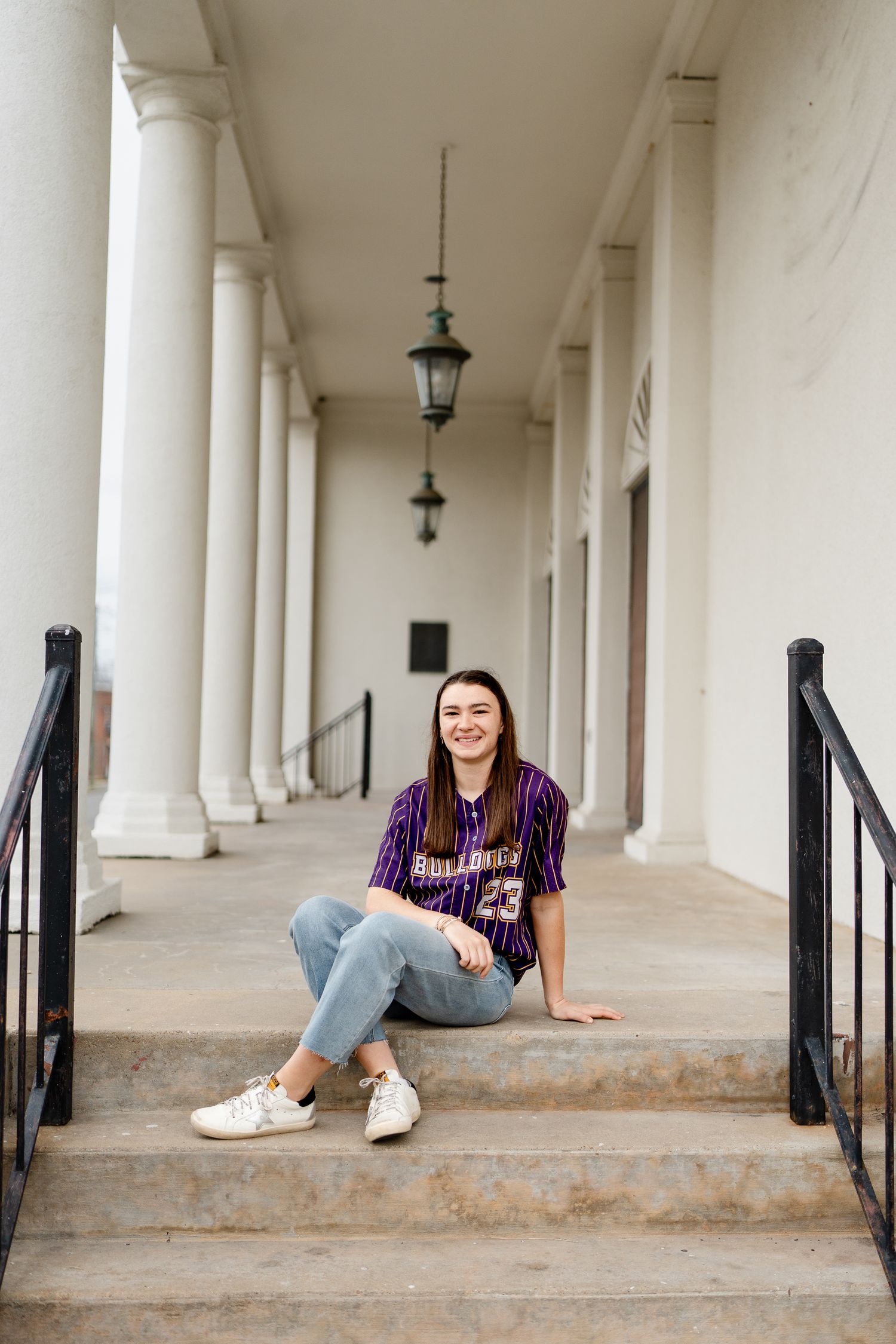 Lifestyle portraits along colonnade featuring vintage sports uniform and casual wear.