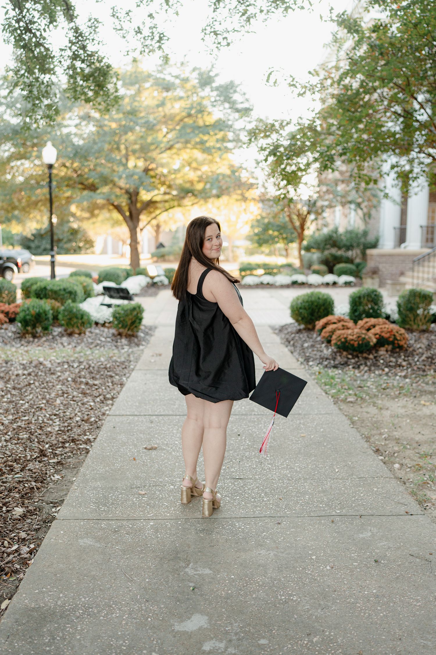 A sequence of dance-like poses captured on a walkway surrounded by landscaping and autumn foliage.