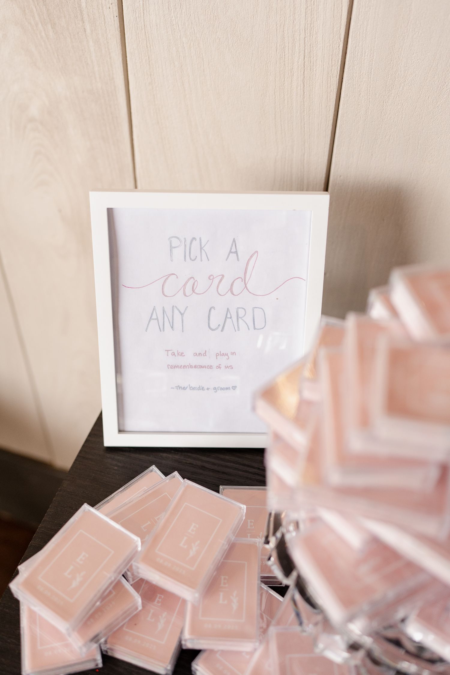 Playing cards arranged on a white surface with a sign that says 'Pick a Card' displayed above them.
