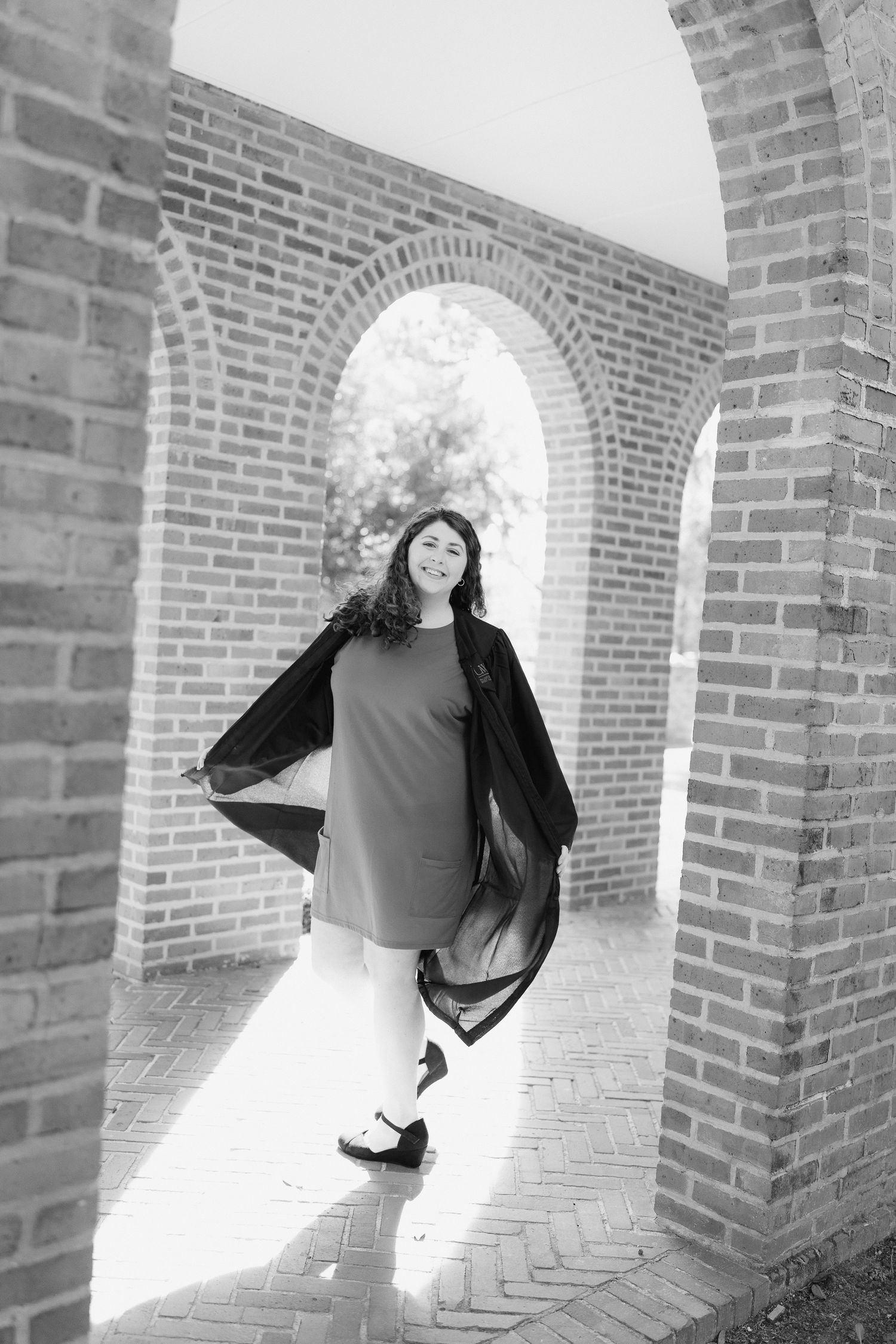 A creative sequence of four photos showing a figure jumping and spinning through a brick archway tunnel.
