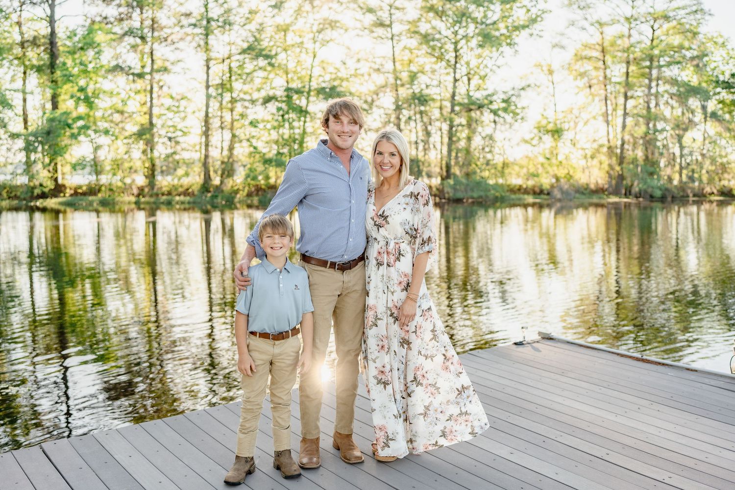 Beautiful lakeside family portraits captured on a wooden dock during golden hour.