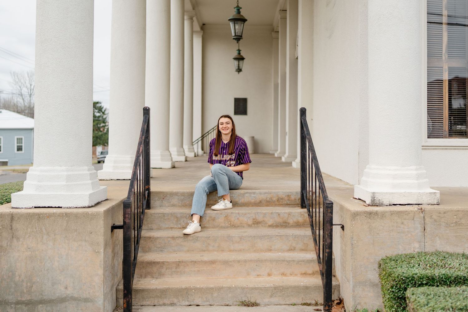 Architectural photo showing white columns and steps with casual athletic styling.
