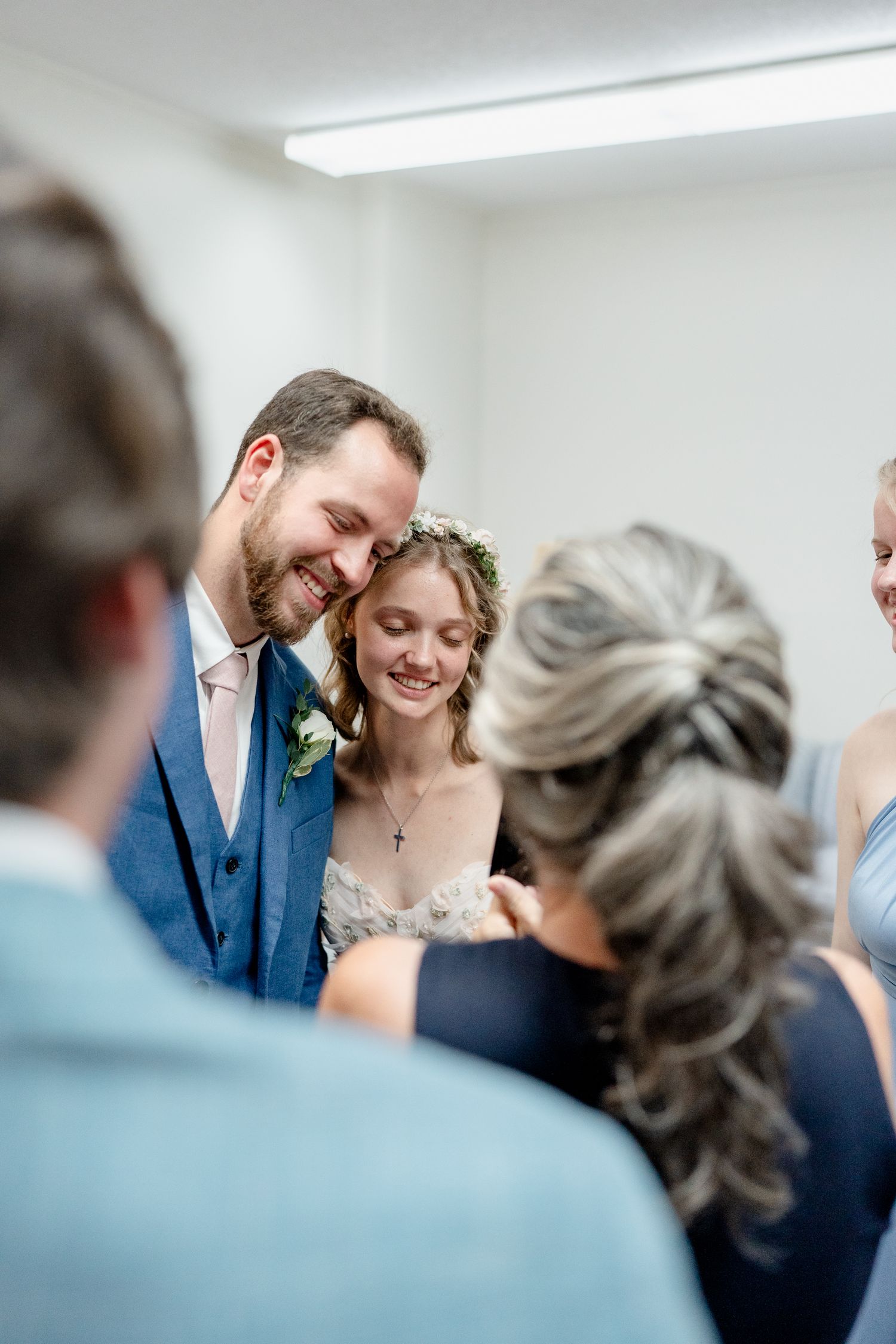 Wedding ceremony attendees gather in a bright church interior space.