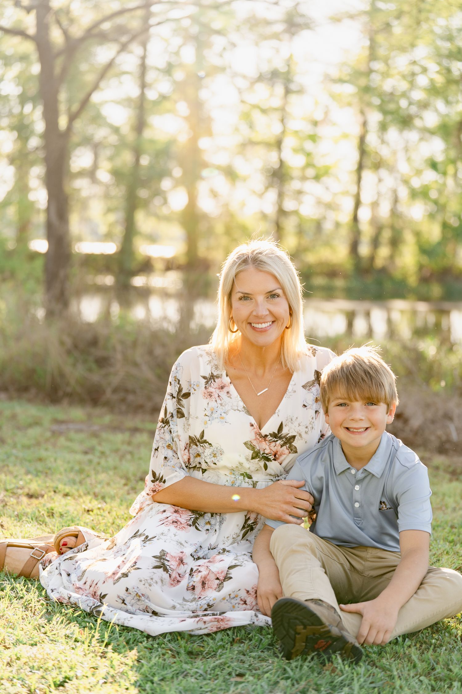 Candid family moments captured on grass during a sunny outdoor portrait session.