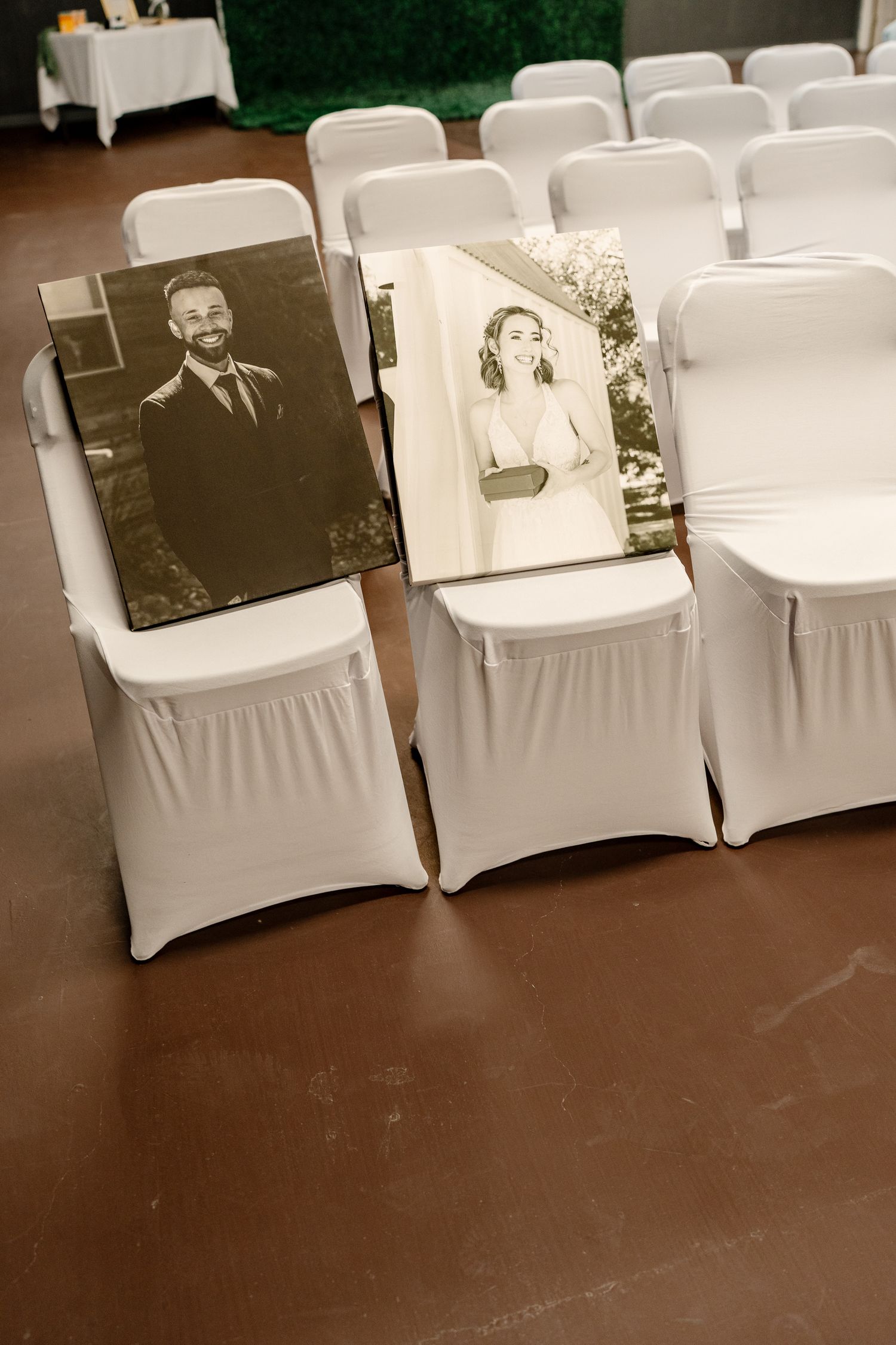 Black and white photographs of loved ones displayed on chairs at a wedding ceremony create a touching memorial tribute.