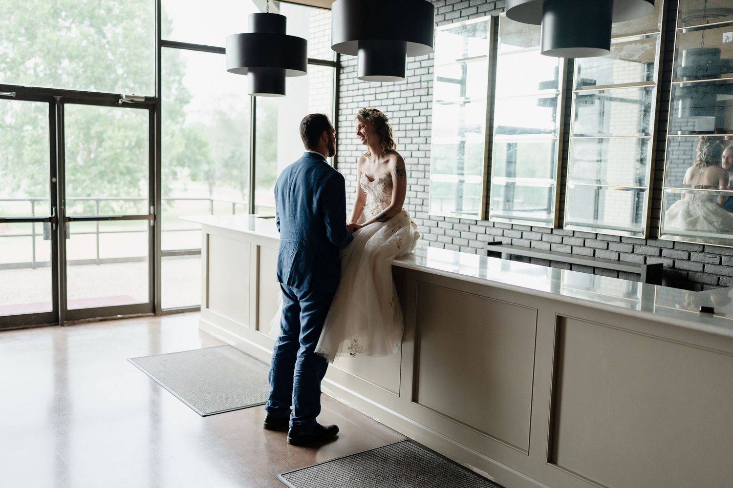 People standing in a bright modern office space with floor-to-ceiling windows and white walls.